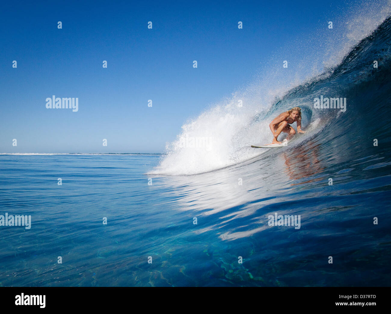 Frau im Kamm der Welle surfen Stockfoto