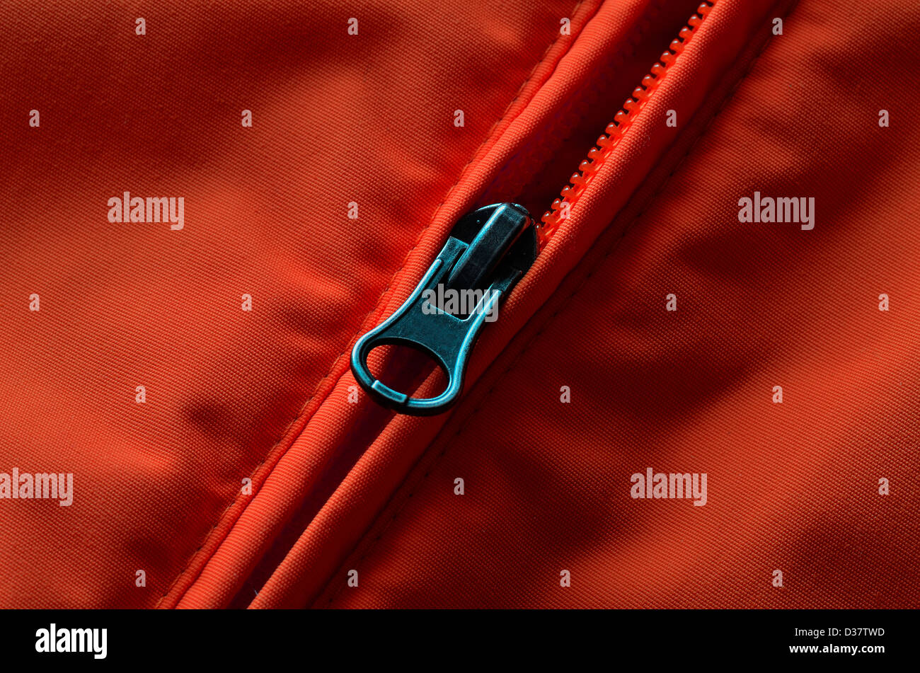 Nahaufnahme des Reißverschlusses auf orange oder roten Mantel mit Textur Stockfoto