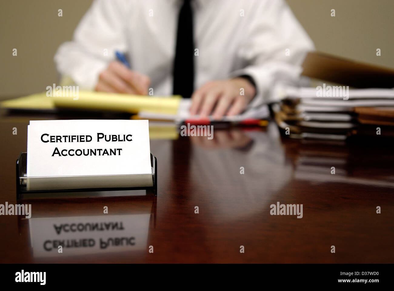 Buchhalter, sitzen am Schreibtisch mit Stapeln von Dateien und Visitenkarte Stockfoto