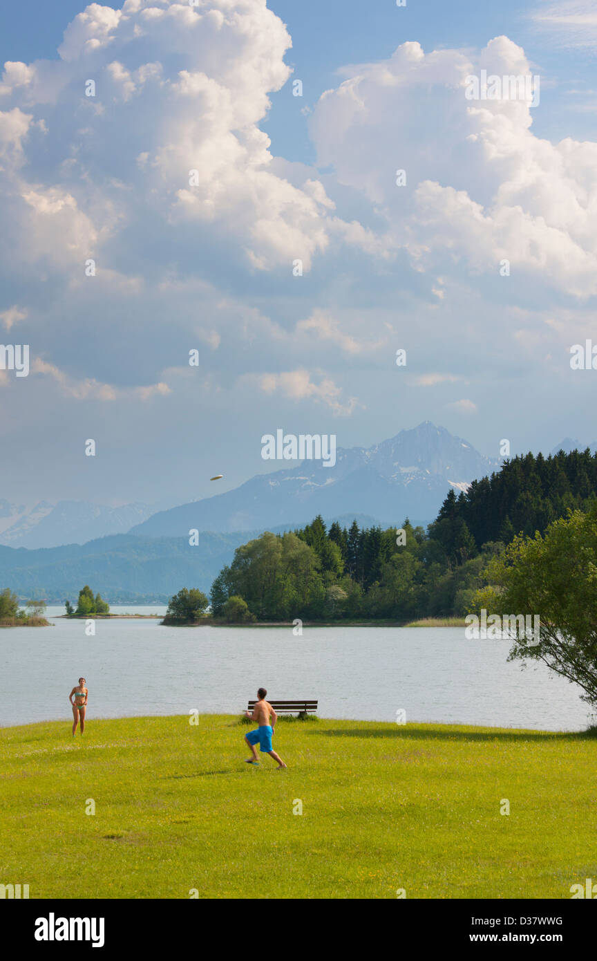 Paar spielen Frisbee durch Illasbergsee, Bayern, Deutschland Stockfoto