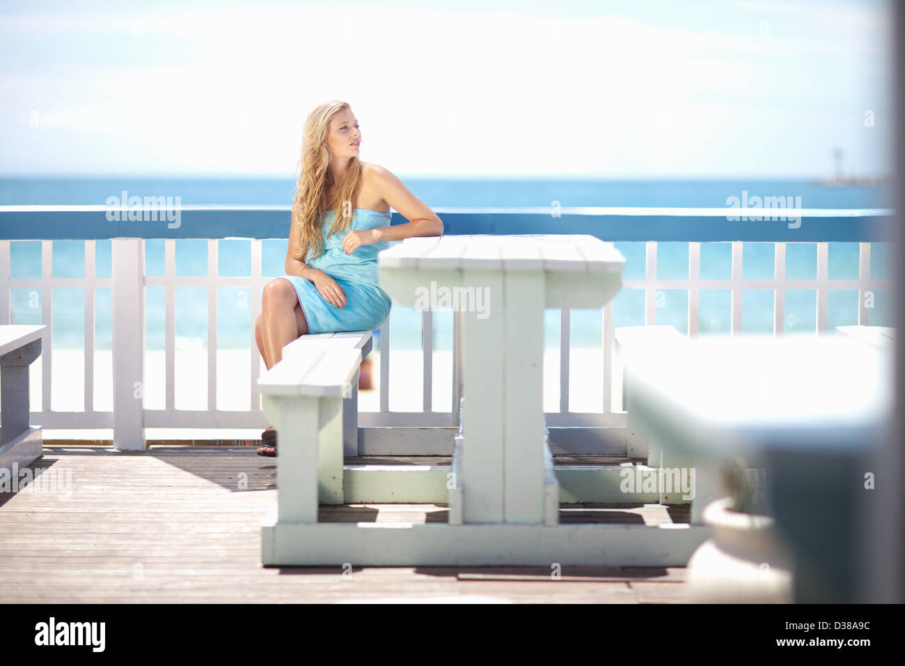 Frau sitzt am Tisch auf dem deck Stockfoto