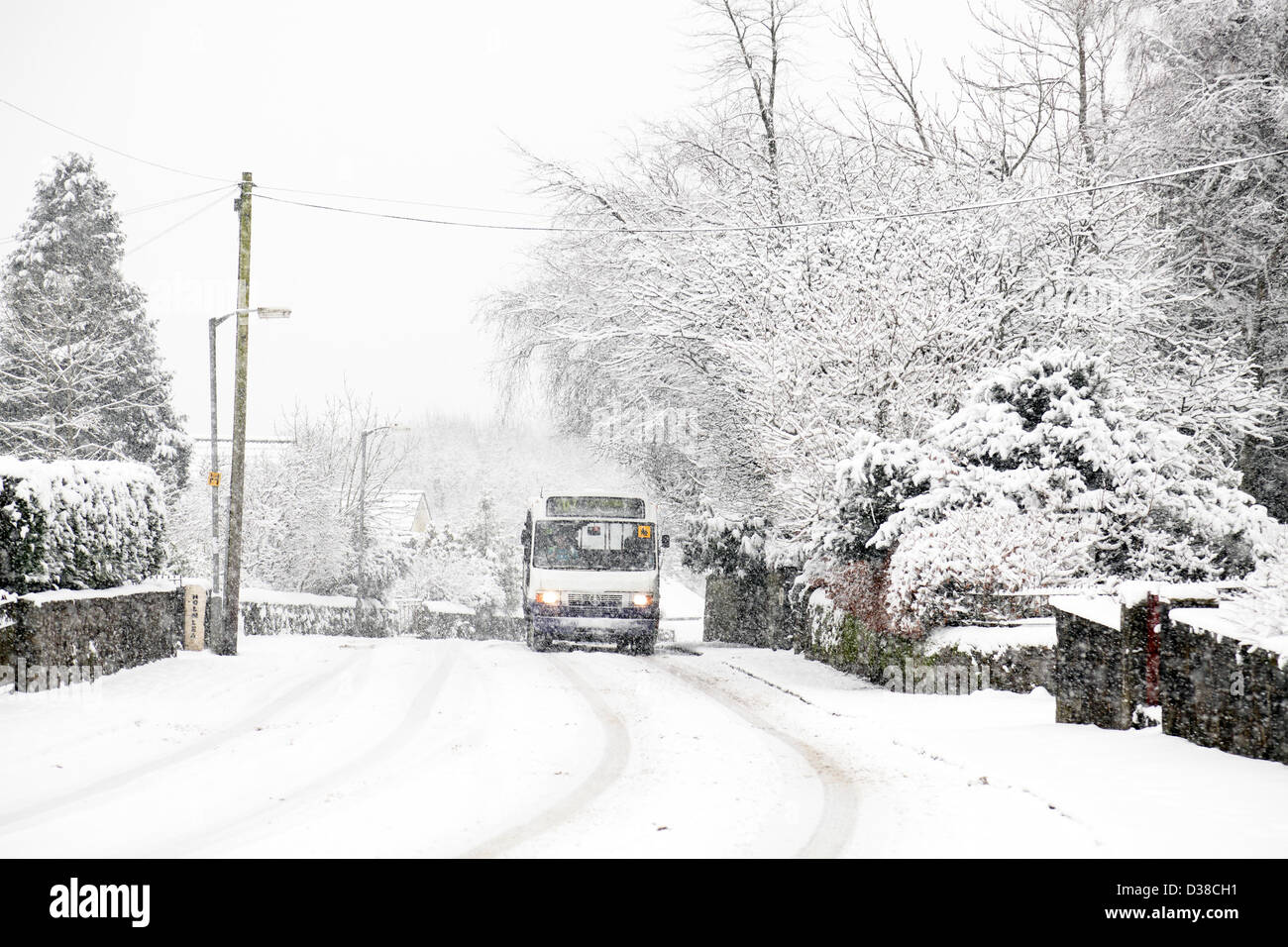 Johnshill, Lochwinnoch, Renfrewshire, Schottland, Großbritannien, Mittwoch, 13th. Februar 2013. Ein Bus, der im fallenden Schnee auf der Hauptstraße durch das Dorf fährt Stockfoto