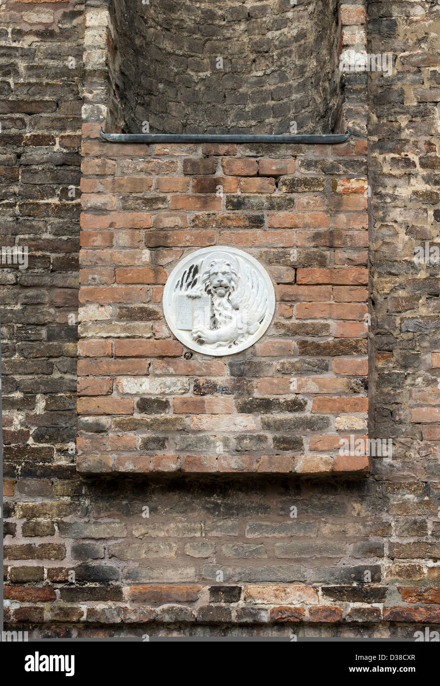 Roten Backsteinmauer in Venedig gebaut im flämischen lag mit einer Runde Relief-Plakette Darstellung ein Löwe und ein Buch, das Emblem des Hl. Markus Stockfoto