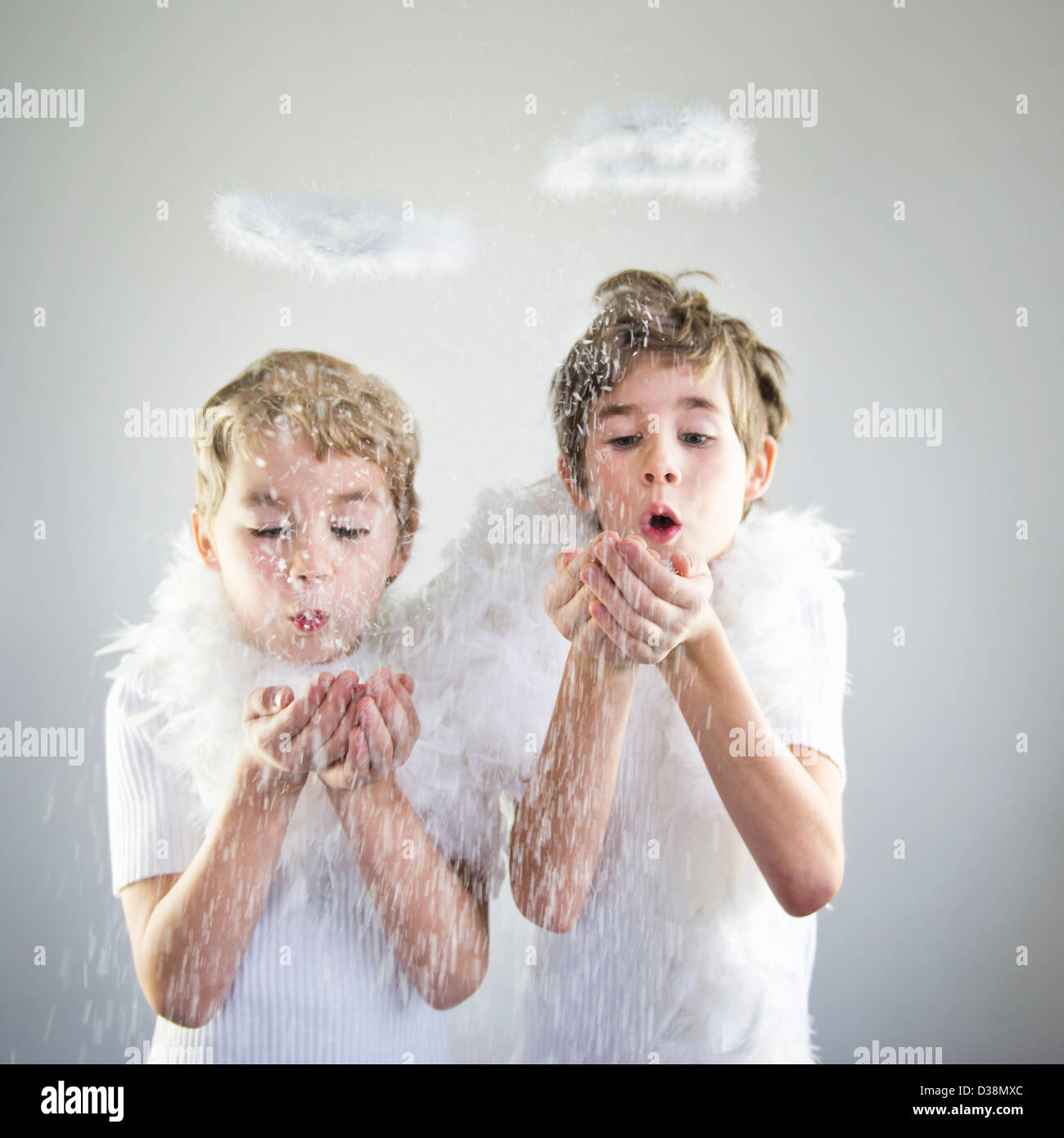 Jungen mit Halos fangen Schnee im Innenbereich Stockfoto