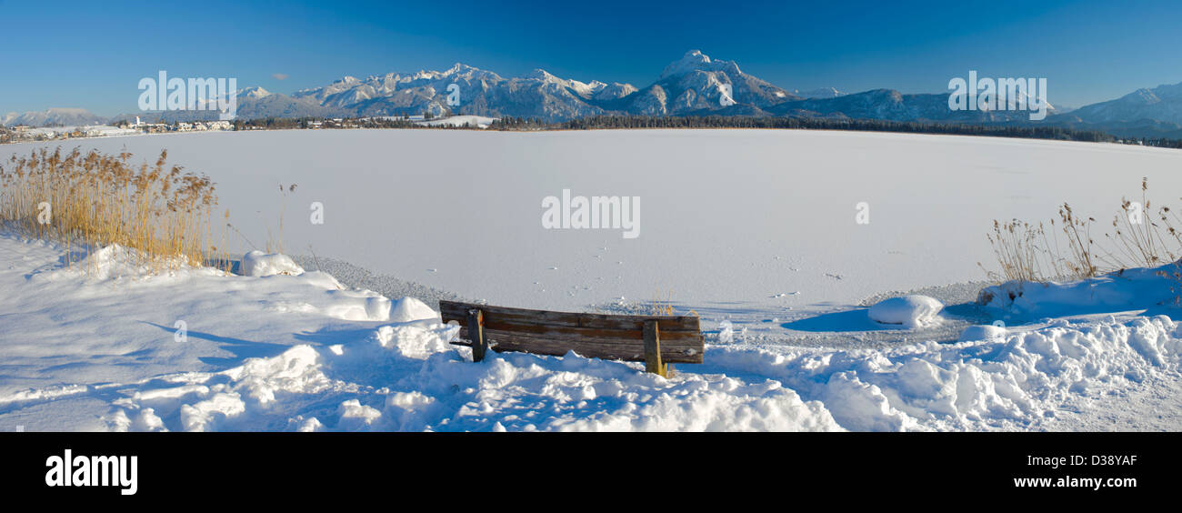 Panoramablick in Bayern, Deutschland, über den See namens Hopfensee zu den Bergen der Alpen am sonnigen Wintertag Stockfoto