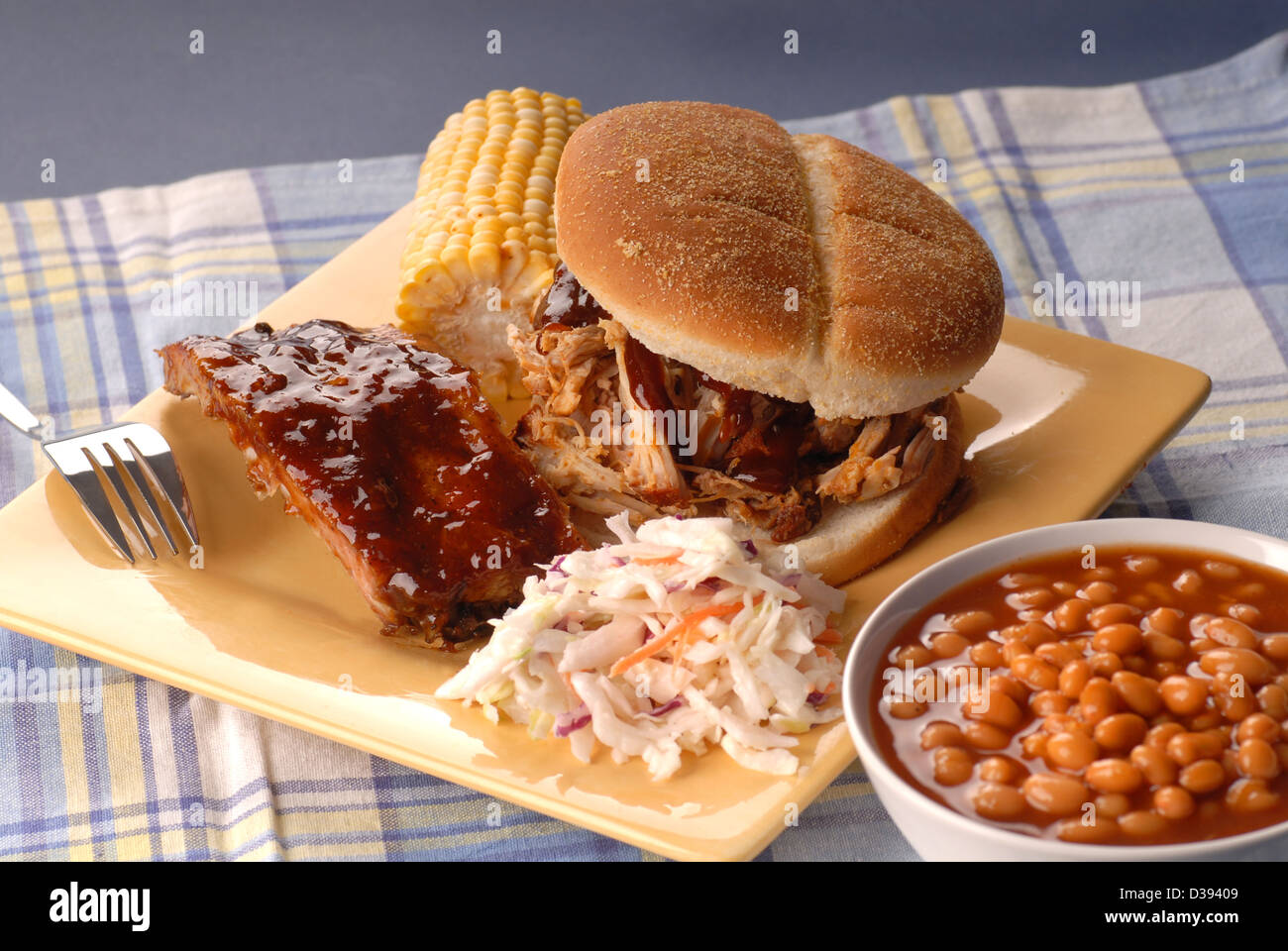 Gezogen Schweinefleisch Sandwich mit Rippen, Bohnen, Mais und Cole slaw Stockfoto