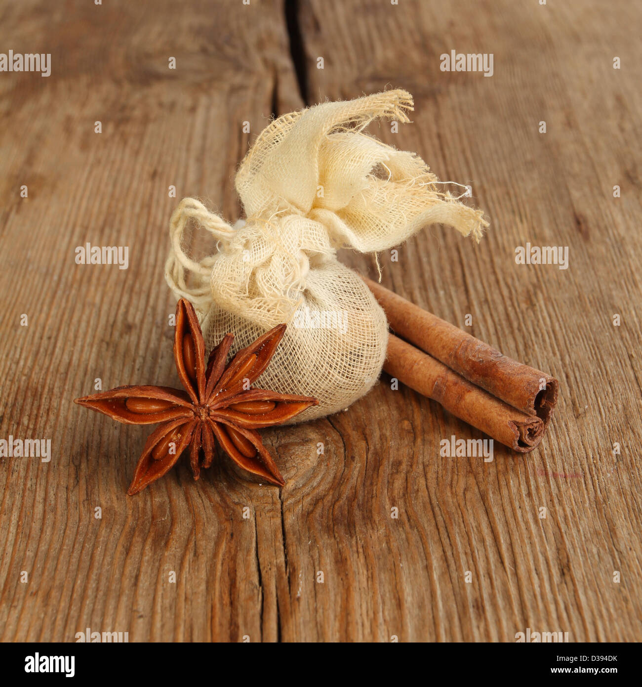 Sternanis, Zimt und einem Musselinbeutel Gewürz auf einem Hintergrund von verwittertem Holz Stockfoto