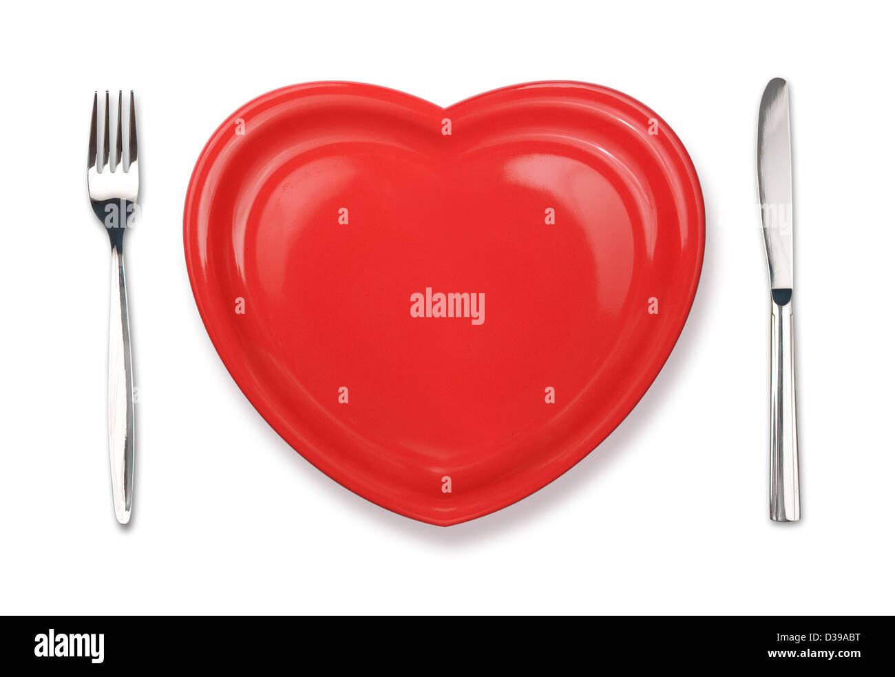 Messer, rote Teller in Herzform und Gabel isoliert auf weiss Stockfoto