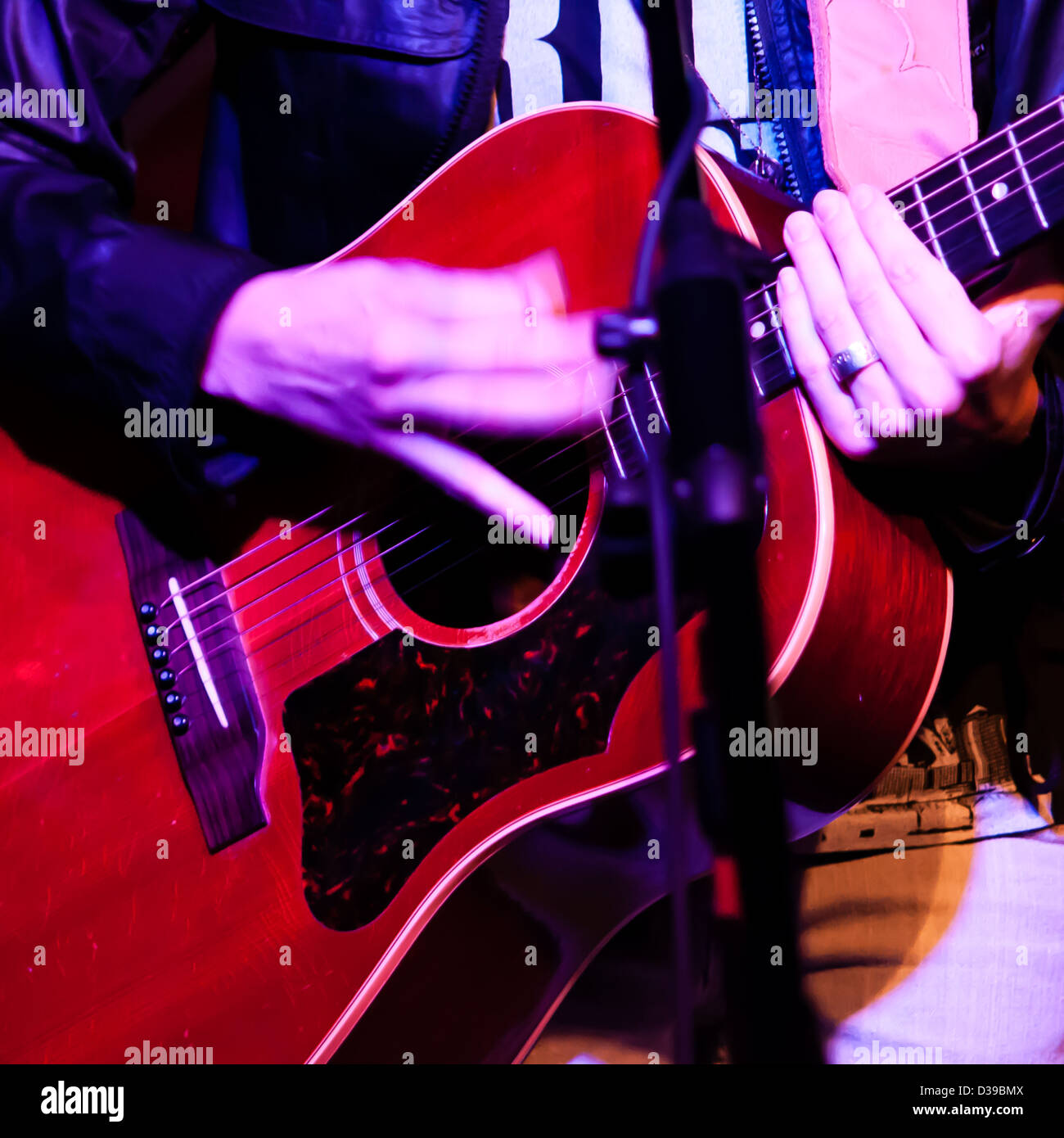 Eine Frau spielt eine rote Gitarre. Stockfoto Eine Frau spielt eine rote Gitarre. Stockfoto