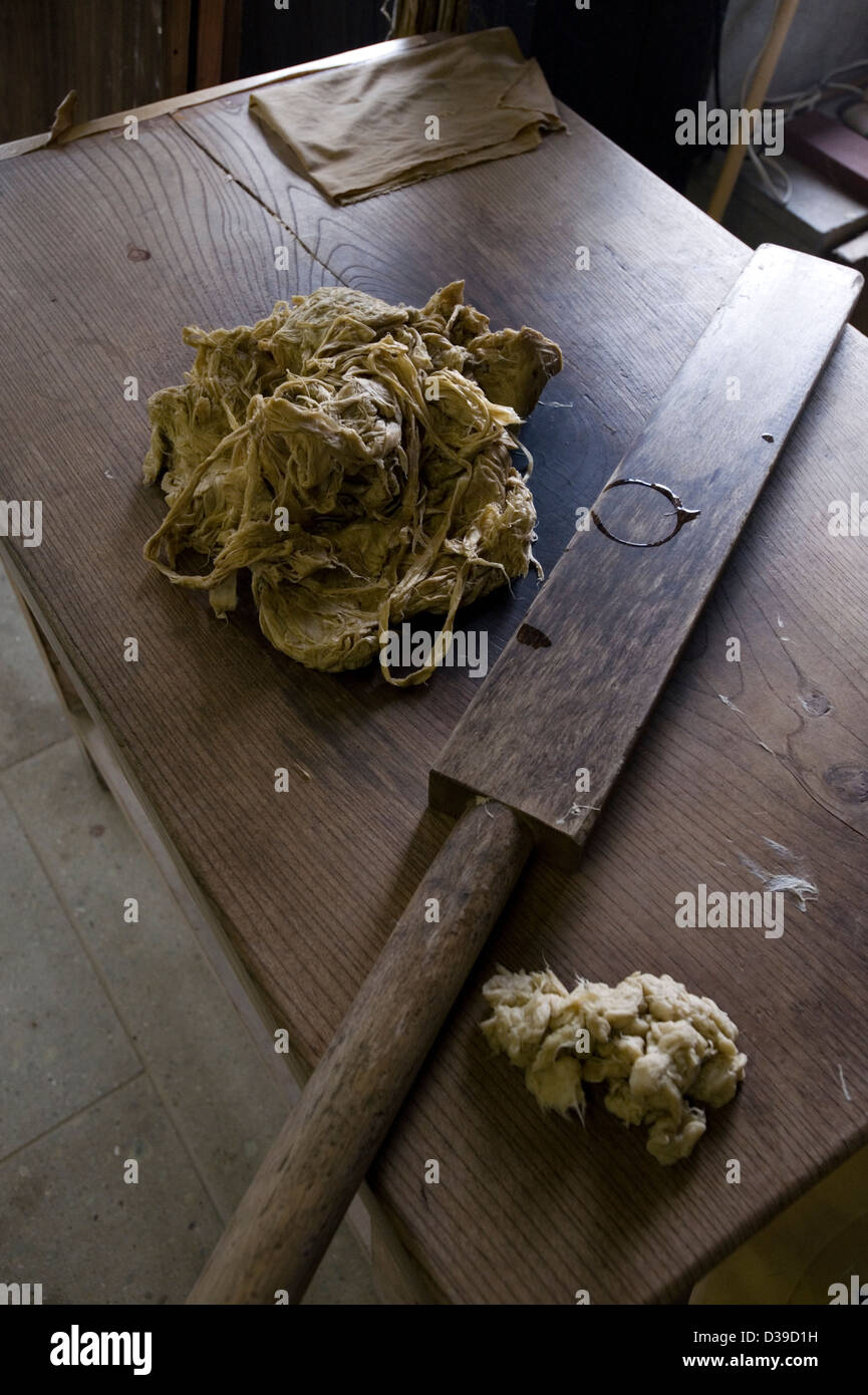 Ein Stück feuchte Maulbeerrindenfasern und ein Holzhammer, um sie für die Herstellung von traditionellem japanischem Washi-Papier zu stampfen, Takefu, Fukui, Japan. Stockfoto