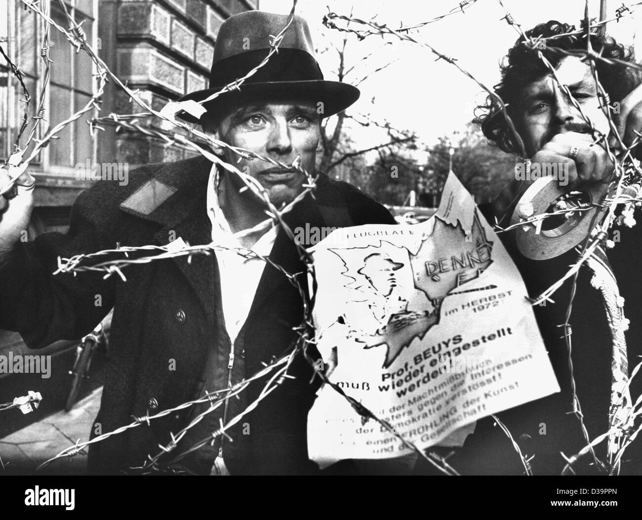 (Dpa-Dateien) - deutscher Künstler und Professor für Kunst, Joseph Beuys (L) an einem Stacheldraht während einer Protestaktion gegen seine fristlose Kündigung an der Kunstakademie in Düsseldorf, 23. November 1972 steht. Der Grund für seine Dimissal war die Besetzung eines Büros mit 80 abgelehnte Bewerber für eine Stockfoto