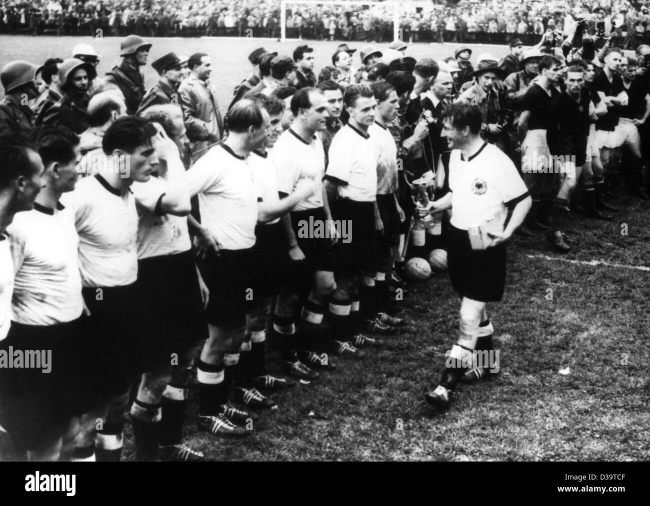 Dpa-Dateien) - Fritz Walter, Kapitän der deutschen  Fußball-Nationalmannschaft, WM-Pokal zu seinen Teamkollegen zeigt, nachdem  die deutsche Mannschaft das Finale gegen Ungarn bei der WM 1954 in Bern,  Schweiz, 4. Juli 1954 gewann.