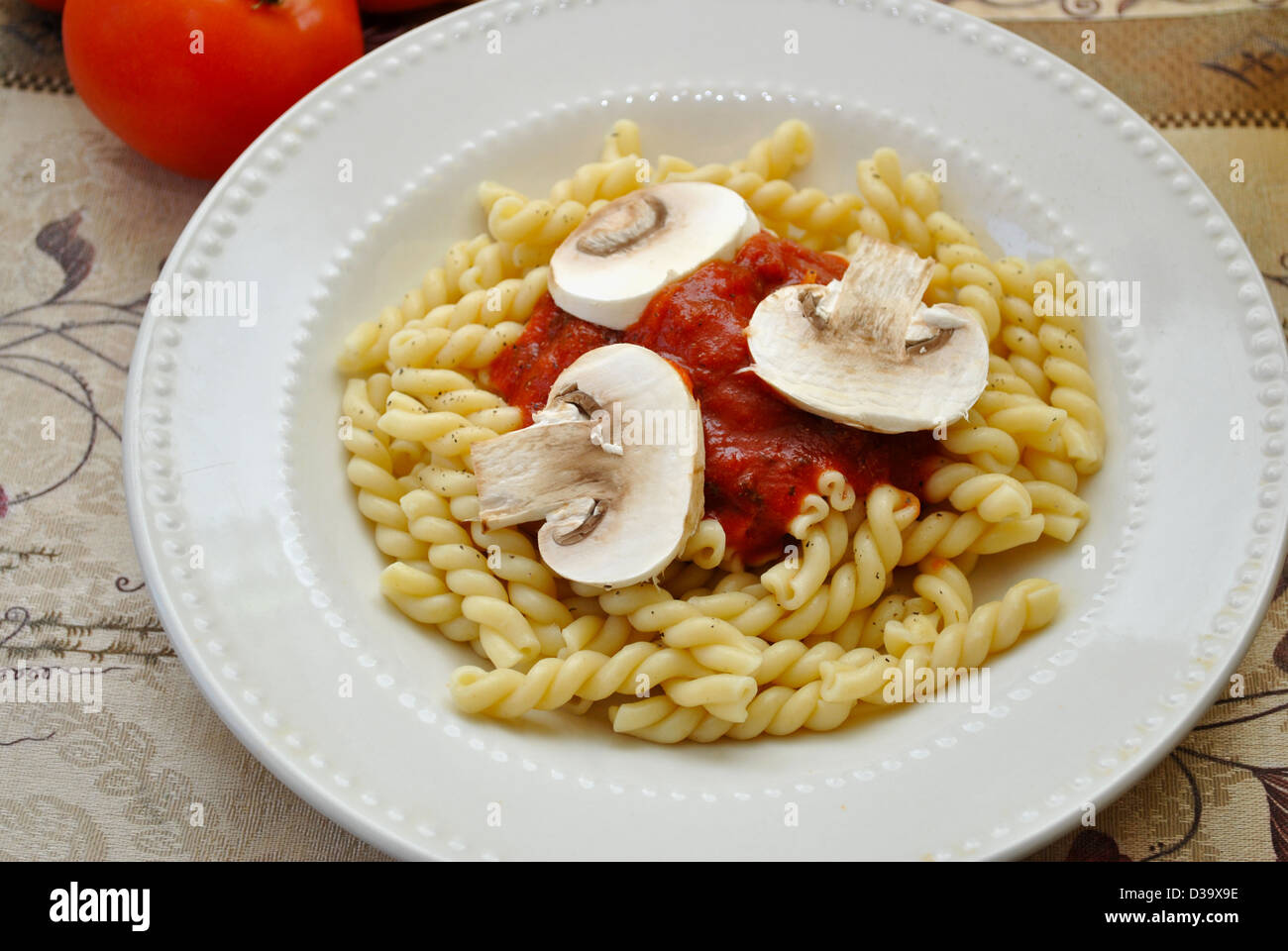 Sauce und in Scheiben geschnittenen Champignons auf Gemelli-Nudeln Stockfoto