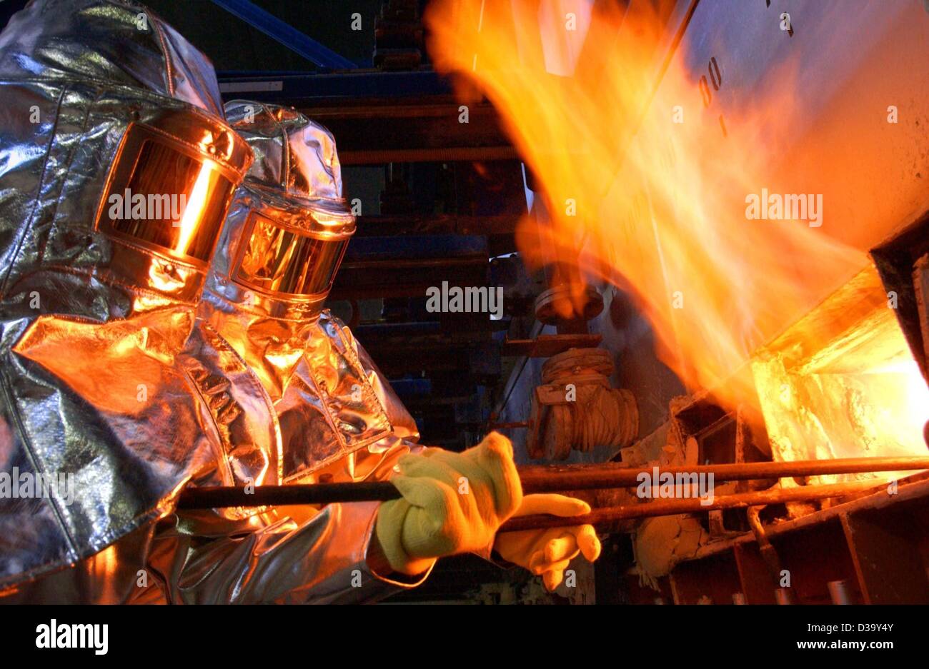 (Dpa) - zwei Mitarbeiter in Schutzkleidung arbeiten an der Fertigungslinie Spezialität Floatglas bei der Glashersteller Schott Jenaer Glas Unternehmen in Jena, Deutschland, 24. Oktober 2003. Das Floatverfahren, das von einer britischen Firma entwickelt und erstmals in den 1950er Jahren verwendet wurde, revolutionierte die Welt Stockfoto
