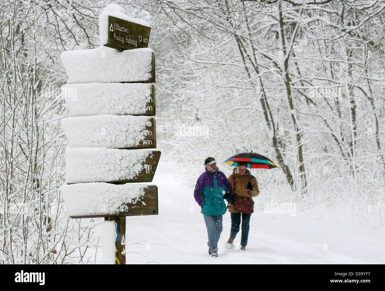 (Dpa) - Menschen machen Sie einen Spaziergang in der verschneiten Habichtswald Wald in der Nähe von Kassel, Mitteldeutschland, 22. Dezember 2003. Ca. 20 cm Neuschnee fielen im Großraum Kassel heute. Stockfoto