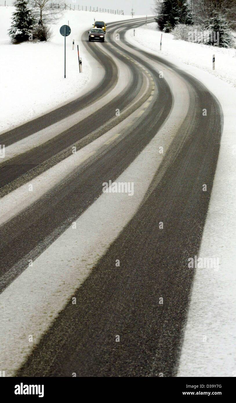 (Dpa) - Autofahrer langsam fahren auf einer verschneiten Straße in der Nähe von Kaufbeuren in Bayern, Deutschland, 22. Dezember 2003. Starker Schneefall hat auf vielen Straßen Chaos geschaffen. Stockfoto