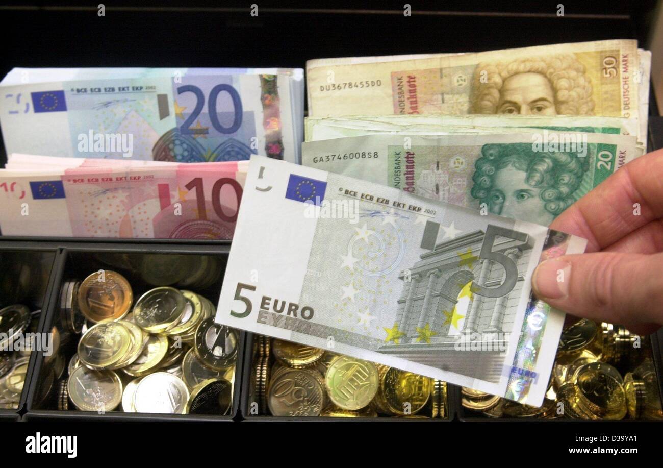(Dpa) - die Kasse eines Supermarktes in Soest / Deutschland ist mit DM und Euro, 1.1.2002 gefüllt. Bis zum 28. Februar werden in die Läden beide Geld akzeptiert. 1. Januar 2002 markiert das offizielle Datum für die Einführung des Euro als gemeinsame Währung für 300 Millionen Bürger in zwölf Europ Stockfoto