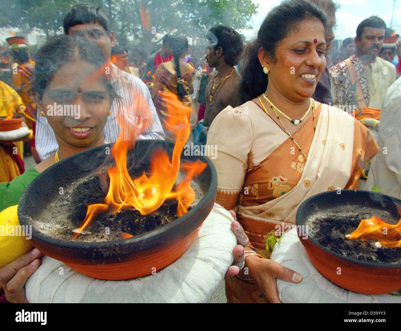 (Dpa) - Schalen Gläubigen Hindu-Frauen tragen des Tones mit dem ewigen Flammen durch die Straßen von Hamm, Deutschland, 26. Mai 2002. Rund 10000 Gläubige aus Deutschland, Frankreich, Belgien und Holland nahmen an dem religiösen hinduistischen Tempel Fest. Stockfoto