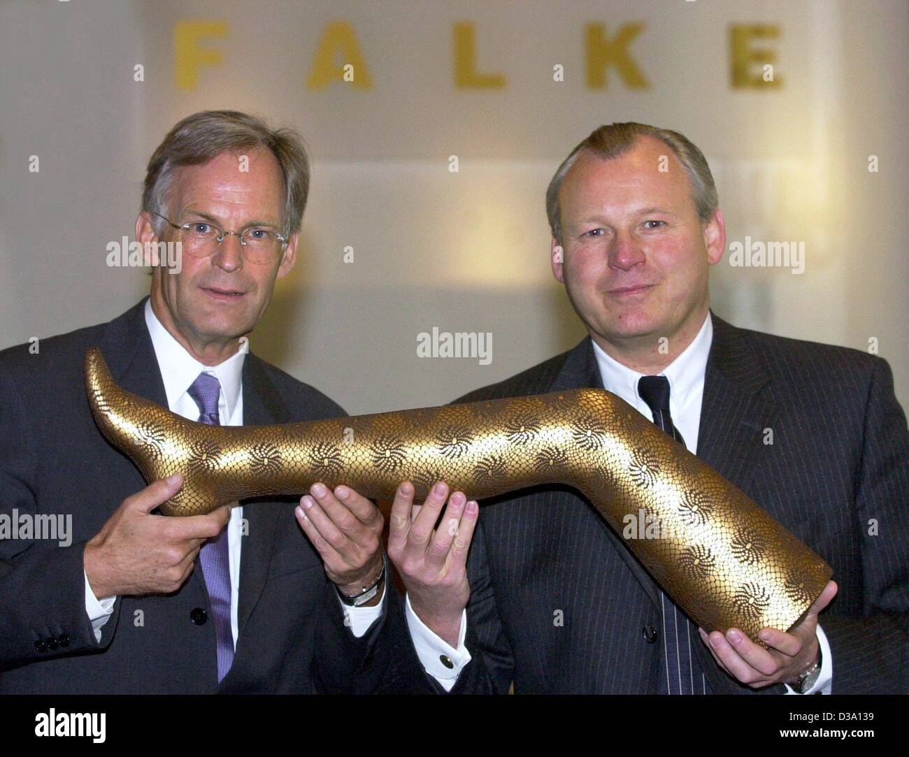 (Dpa) - Franz-Peter Falke (L) und Paul Falke, die beiden Geschäftsführer der deutschen Strümpfe und Bekleidungsunternehmen Falke Gruppe, zeigen das Bein ein Dummy tragen goldene Strümpfe in Düsseldorf, 7. Mai 2002. Stockfoto