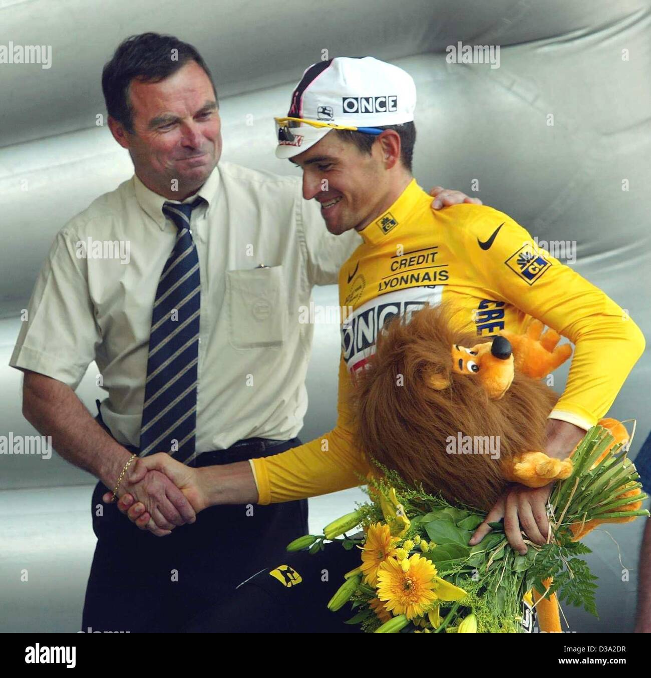 (Dpa) - die fünf Tour De France Sieger Bernard Hinault (L) schüttelt Hände mit der spanische Radfahrer Igor Gonzalez de Galdeano des einmal-Ersoki-Teams, die während der 9. Etappe der Tour De France in Pont-Scorff, 15. Juli 2002 das gelbe Trikot trägt. Stockfoto