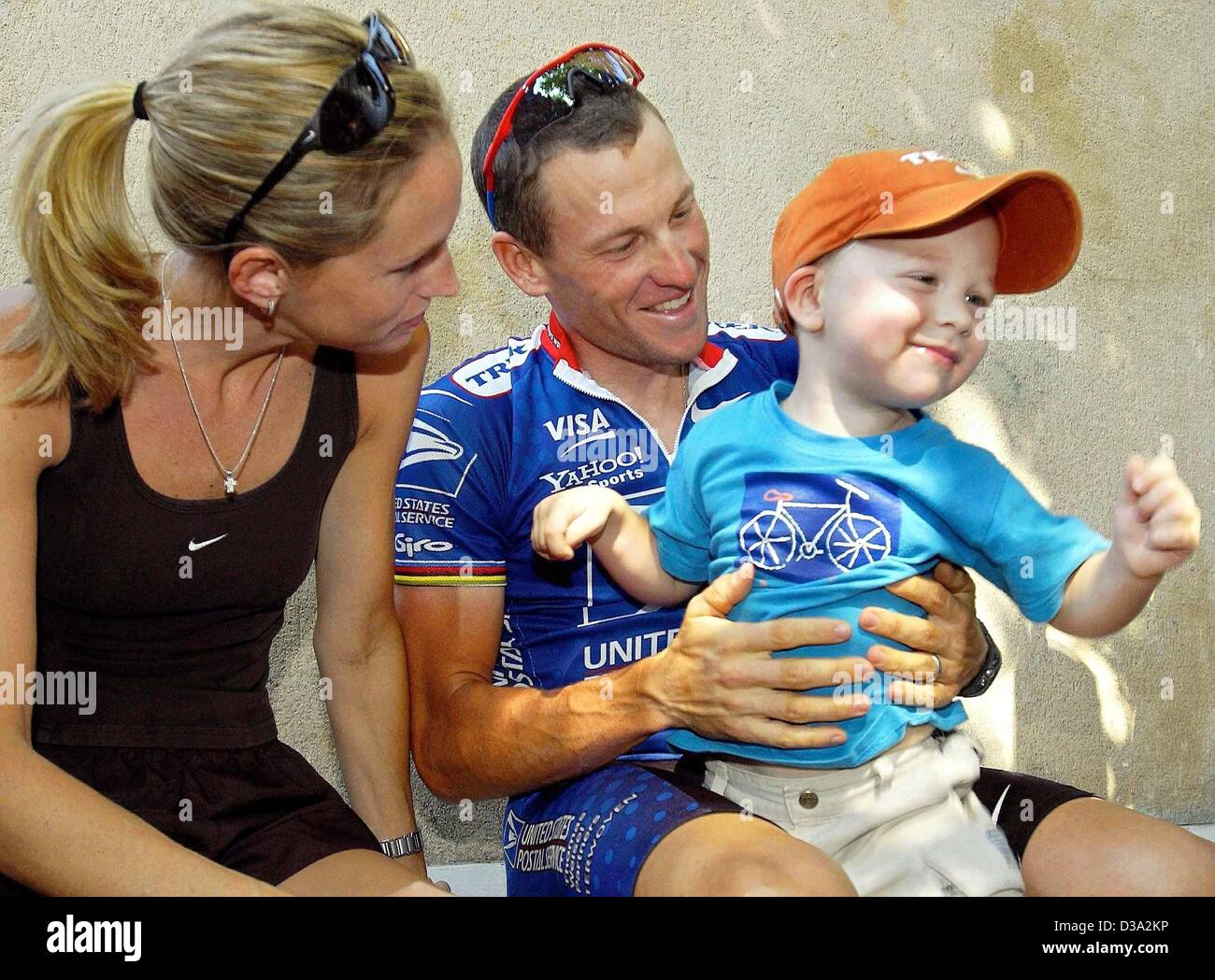(Dpa) - US Lance Armstrong Witze mit seinem Sohn Luke, der sitzt auf seinem Schoß, während seine Frau Kristin blickt auf vor dem Training vor der 15. Etappe der Tour De France in St. Paul-Trois-Chateaux, 22. Juli 2002. Stockfoto