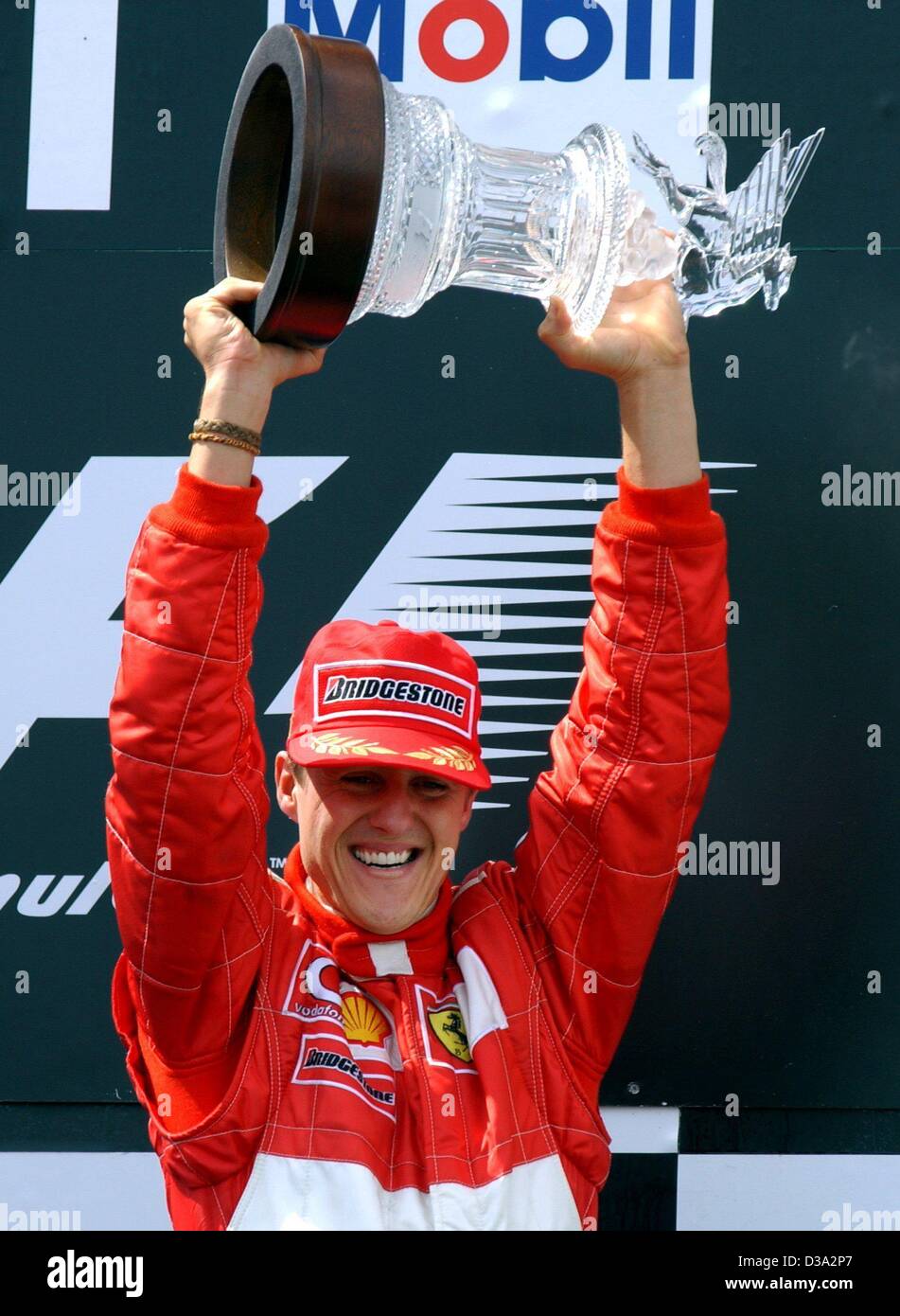 (Dpa) - deutsche Formel 1-Pilot Michael Schumacher mit seiner Trophäe jubilates nach dem Gewinn der französischen Formel Eins Grand Prix auf der Rennstrecke von Magny-Cours in Frankreich, 21. Juli 2002. Dank diesem Sieg gewann Schumacher zum fünften Mal den Weltmeistertitel. Sechs weitere Rennen bis zu den Stockfoto