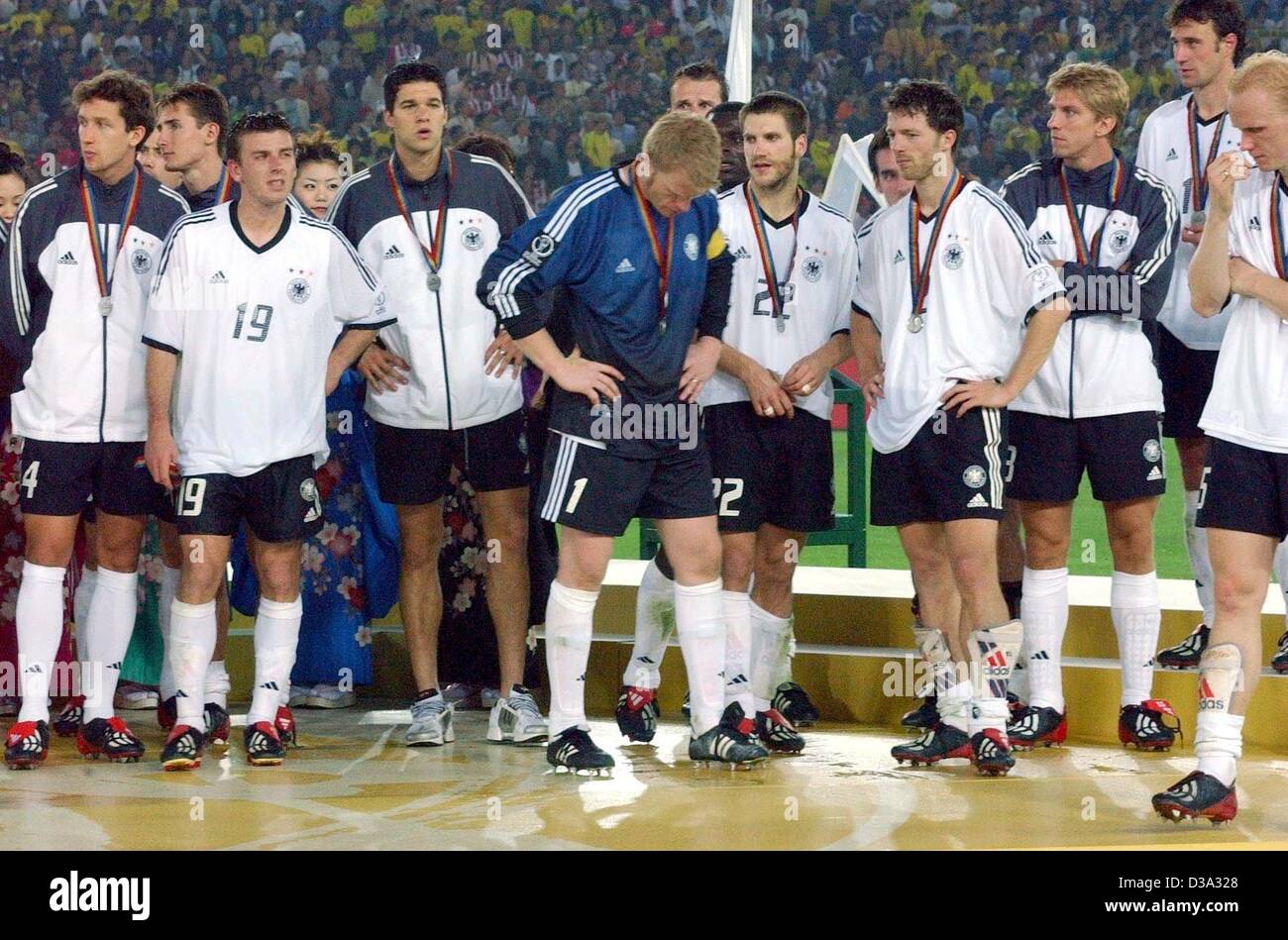 (Dpa) - stellen die deutsche Mannschaft mit ihren Medaillen nach der Niederlage in der FIFA-WM-Finale gegnerische Deutschland und Brasilien in Yokohama, Japan, 30. Juni 2002. Das Spiel endete 2:0 für Brasilien, Brasilien einen fünffachen Rekordweltmeister und Deutschland gewann den 2. Platz. Von L-r: Frank Baumann, Miros Stockfoto