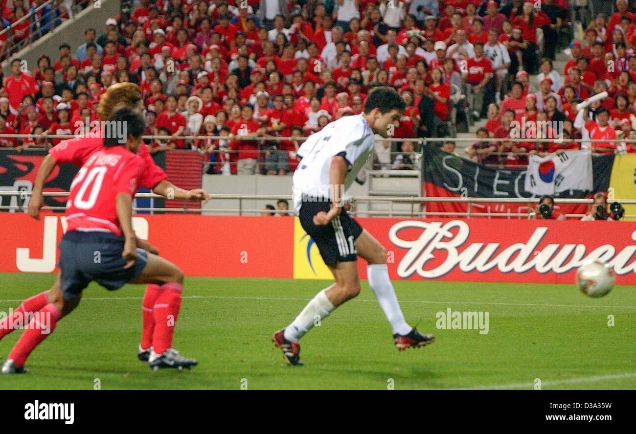 (Dpa) - deutsche Mittelfeldspieler Michael Ballack (R) macht einen Schuss auf das Tor mit koreanischen Spieler Hong Myung-Bo (L, vorn) und Yoo Sang-Chul (L, bedeckt) auf den Fersen im Halbfinale des FIFA World Cup in Seoul, 25. Juni 2002. Spiel gegen Südkorea qualifiziert 1:0 Deutschland zum 7. Mal für die WM Stockfoto