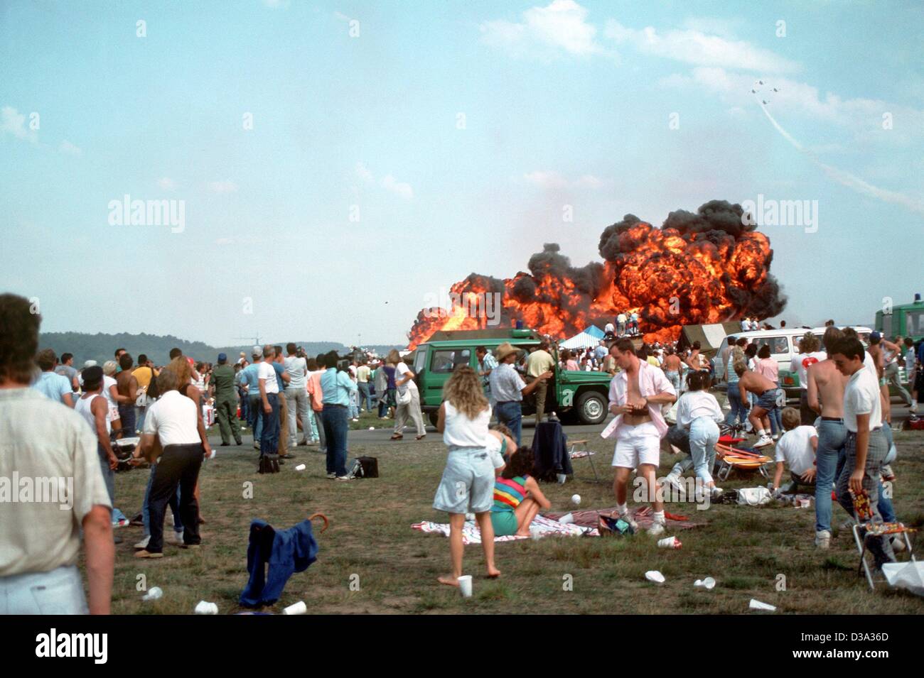 (Dpa-Dateien) - eine Gruppe von Menschen entsetzt beobachten die katastrophalen Flugzeugabsturz während der Luftfahrt auf dem US-Luftwaffenstützpunkt in Ramstein, Deutschland, 28. August 1988 zeigen. Ein Jet der italienischen Stunt-Flying Squadron "Frecce Tricolori" hatte kollidierte mit zwei anderen Jets und explodierte, krachte in eine Menschenmenge von spec Stockfoto
