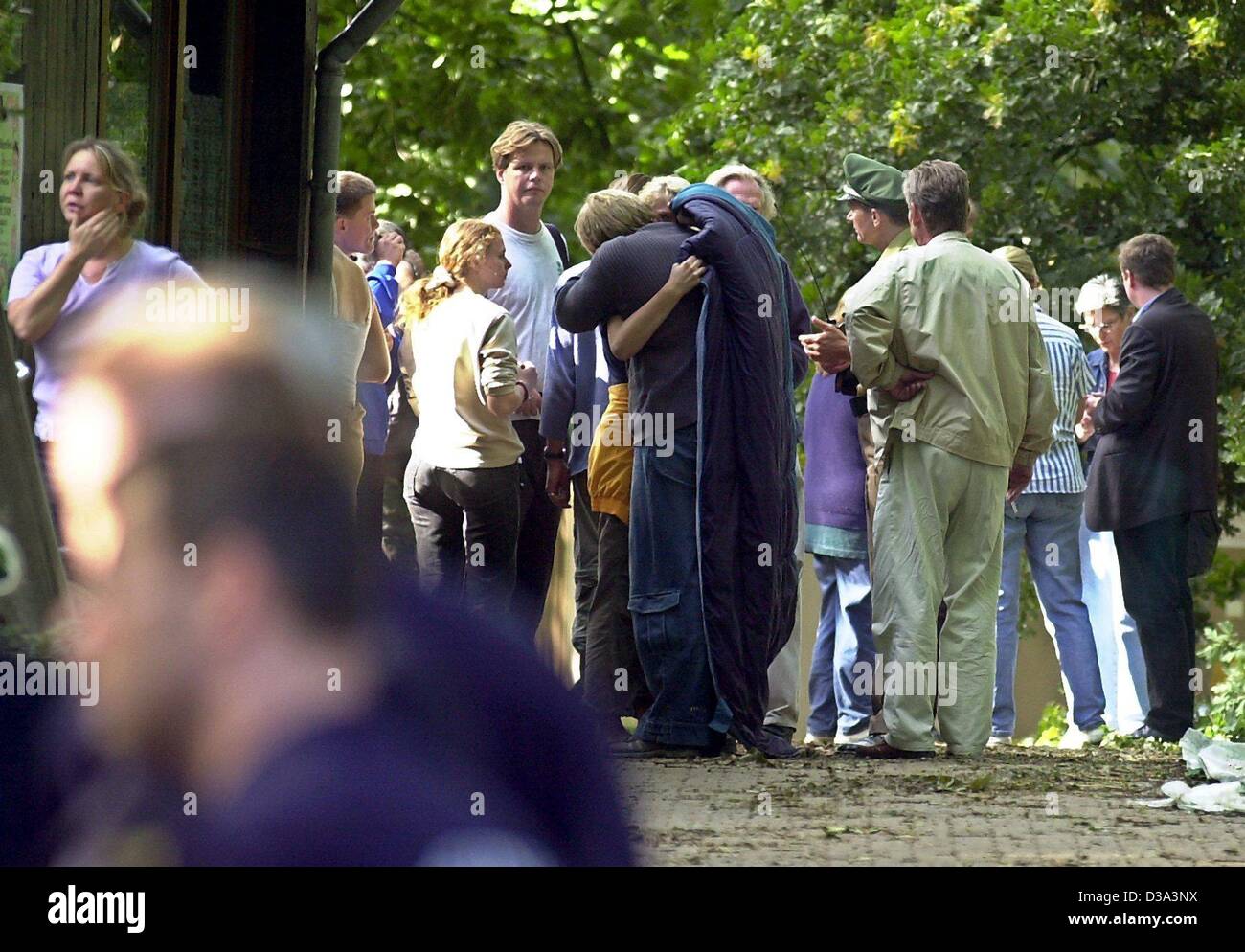 (Dpa) - eine Gruppe von jungen Menschen trösten einander auf dem Campingplatz in Berlin, 11. Juli 2002, wo zwei Jungs durch umstürzende Bäume in der letzten Nacht Sturm ums Leben kamen. Zwölf weitere Jugendliche und ihre Betreuer wurden verletzt. In dem verheerenden Sturm, der durch Berlin und Umland mit Winde Rea fegte Stockfoto