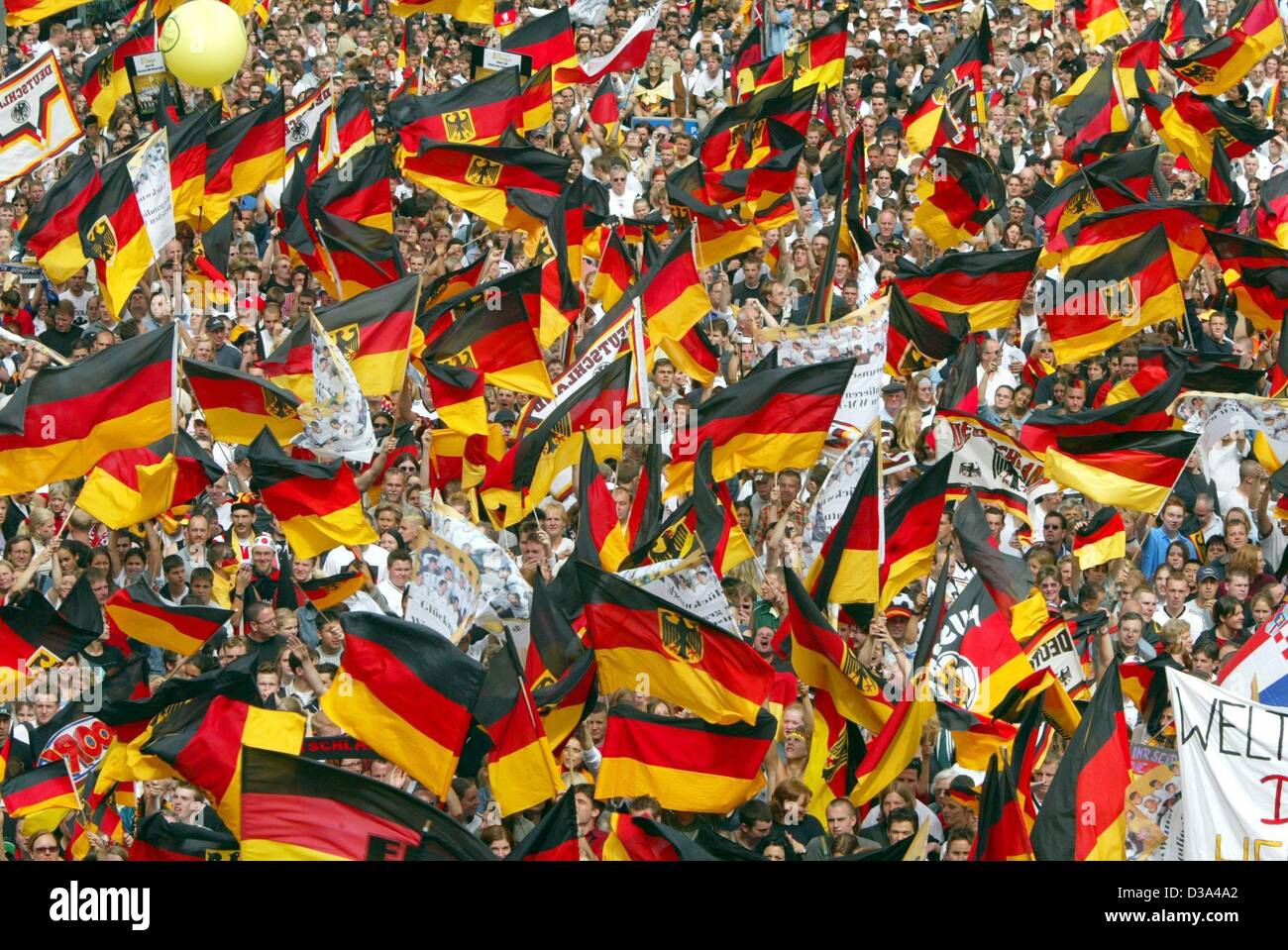 (Dpa) - ist ein Meer von Fahnen schwenkten, wie Tausende von Fußball-Fans warten auf die Ankunft der deutschen Nationalmannschaft für ein Rathaus-Empfang auf dem Römer Platz in Frankfurt am Main, 1. Juli 2002. Deutschland gewann die zweite Platzierung im Weltcup, nach der Niederlage im Finale Welt Weltmeister Brasilien in Yokohama 0:2. Stockfoto