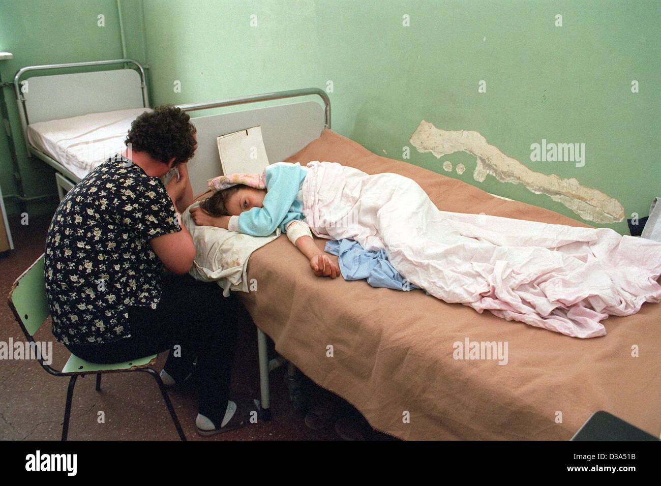 (Dpa-Dateien) - sitzt eine dispaired Mutter am Bett ihrer Tochter, die mit dem HIV-Virus im städtischen Krankenhaus in Constanta, Rumänien, 2. Juni 2001 infiziert ist. Das Krankenhaus ist ein Haus für Kinder, die an Aids leiden, und Ärzte betreut insgesamt 920 infizierten Kindern im Bezirk Con Stockfoto