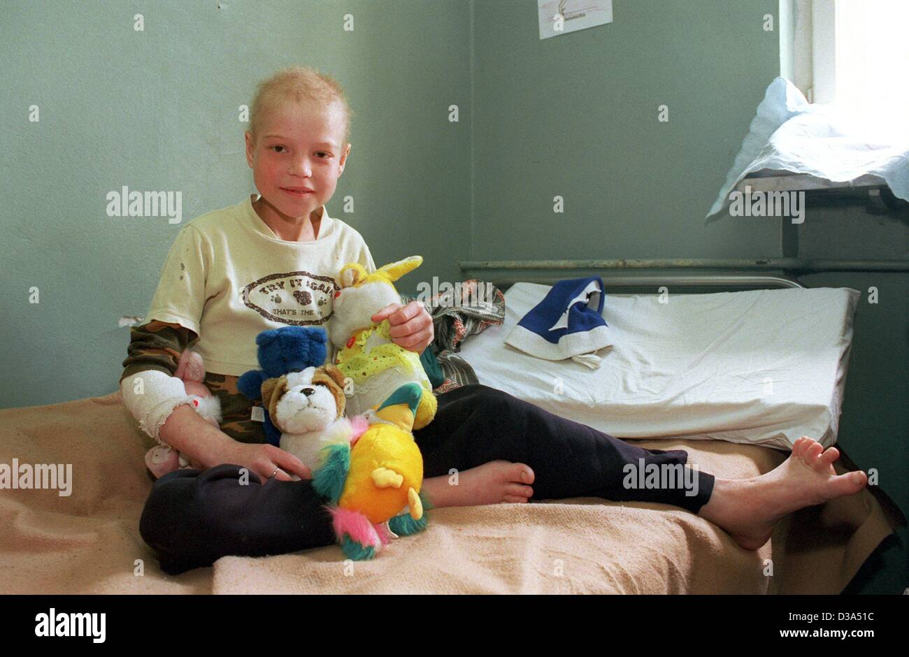 (Dpa-Dateien) - sitzt auf ihrem Bett in das städtische Krankenhaus in Constanta, Rumänien, 2. Juni 2001 eine schwerkranke Mädchen mit dem HIV-Virus infiziert mit ihren Spielzeugen. Das Krankenhaus ist ein Haus für Kinder, die an Aids leiden, und Ärzte betreut insgesamt 920 infizierten Kindern im Bezirk Constanta. T Stockfoto