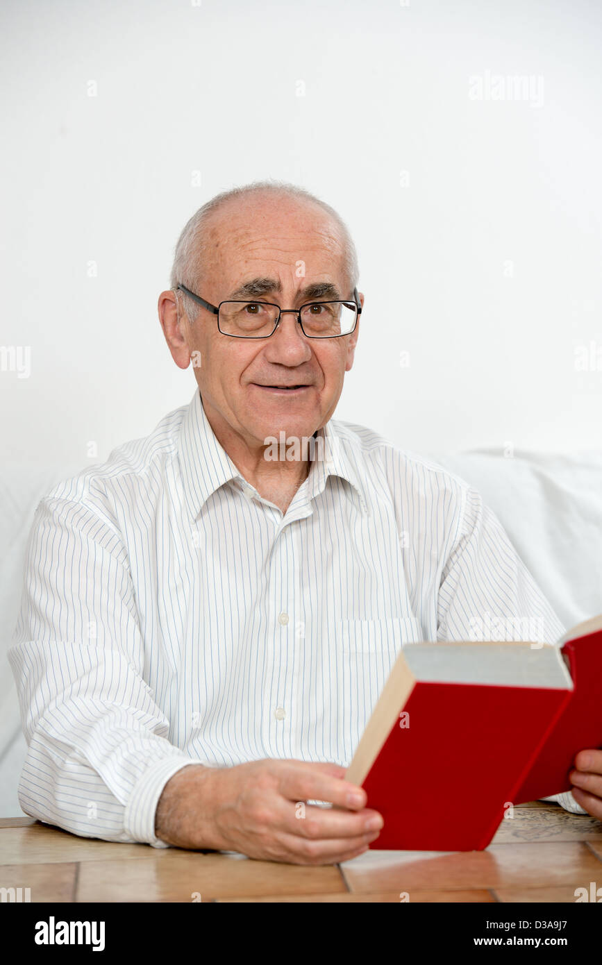 alte rote Buch lesen und lächelnd auf weißem Hintergrund Stockfoto