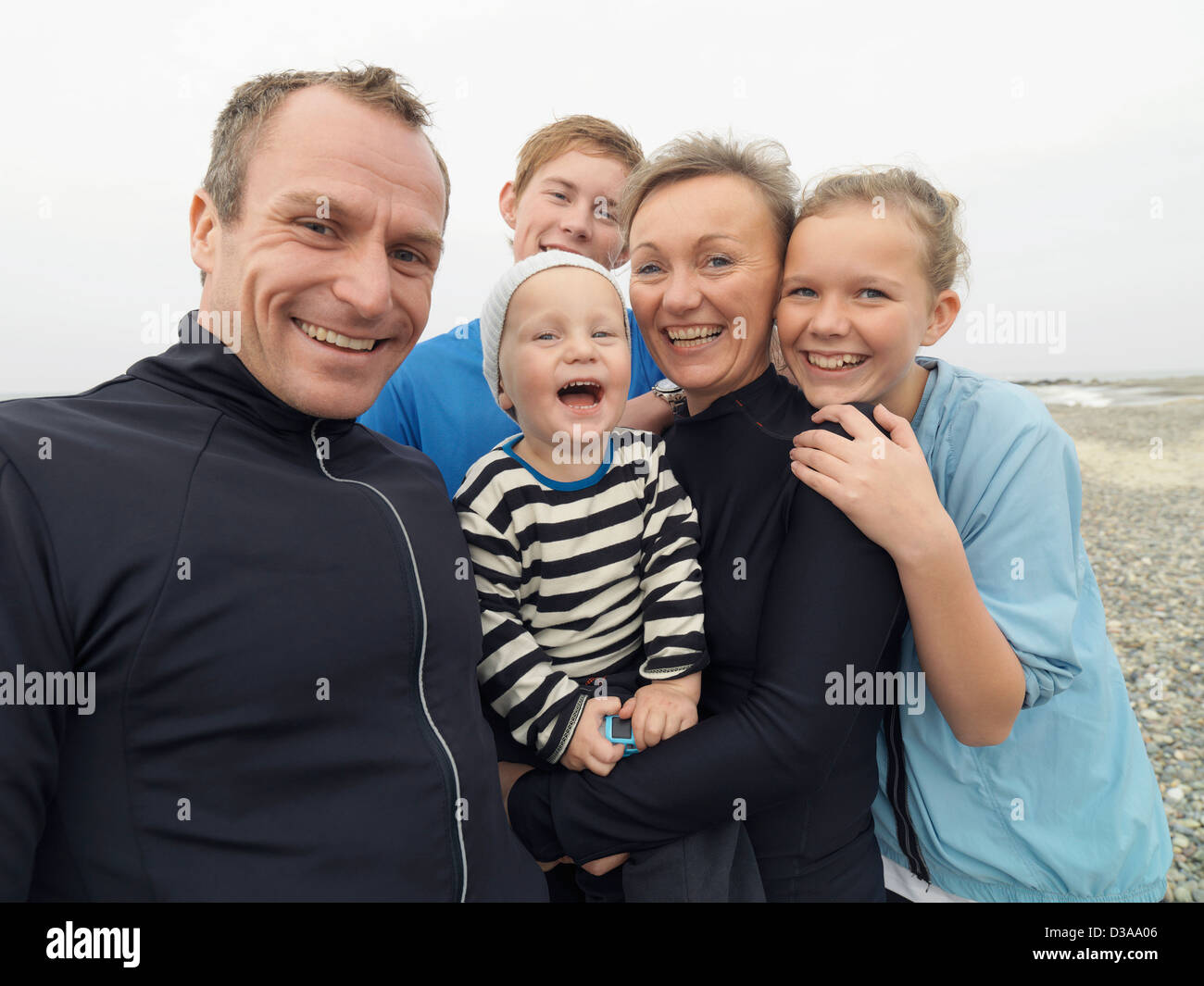 Familie gemeinsam lachen auf felsigen Strand Stockfoto