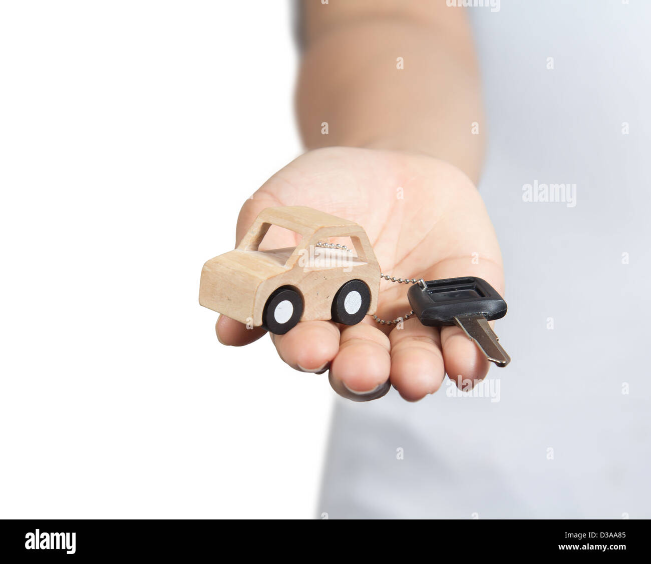 Schlüssel und Auto aus Holz in der Hand. Stockfoto