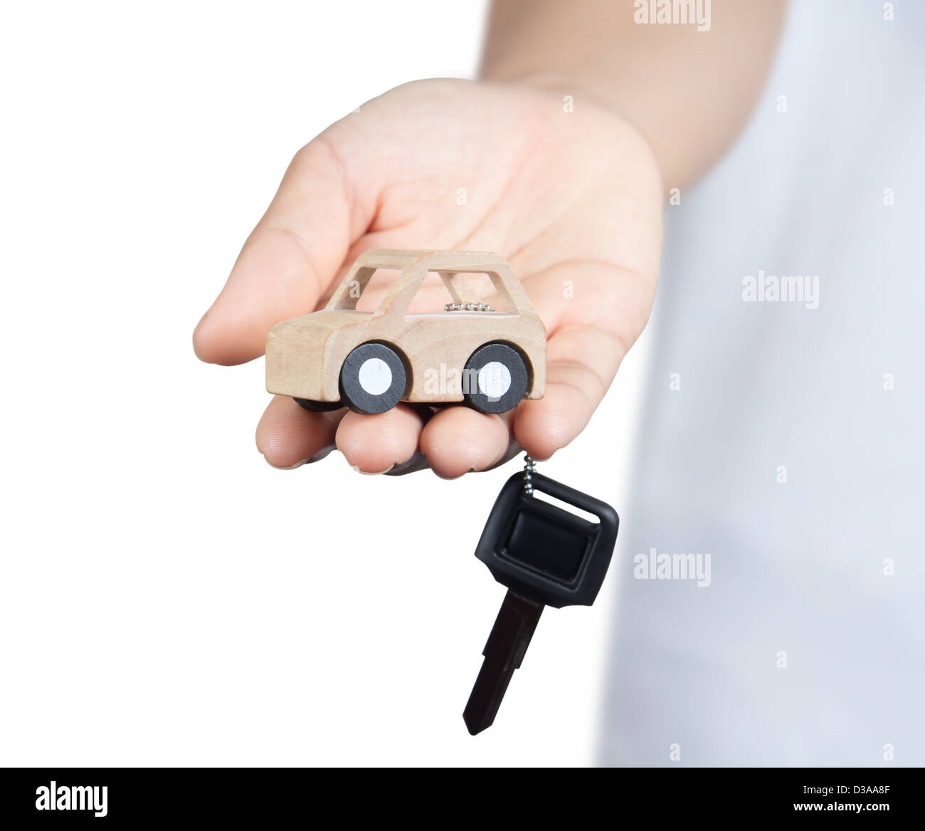 Schlüssel und Auto aus Holz in der Hand. Stockfoto