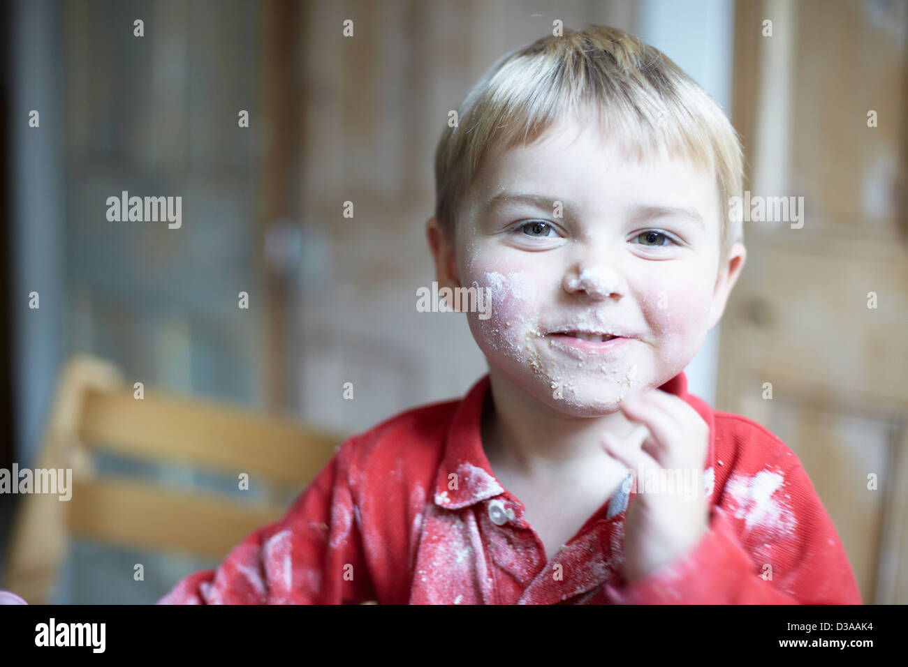 Jungen-Gesicht mit Mehl in Küche Stockfoto