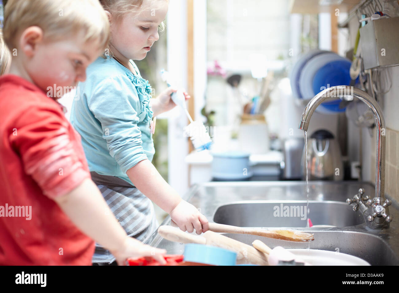 Kinder beim Abwasch zusammen Stockfoto