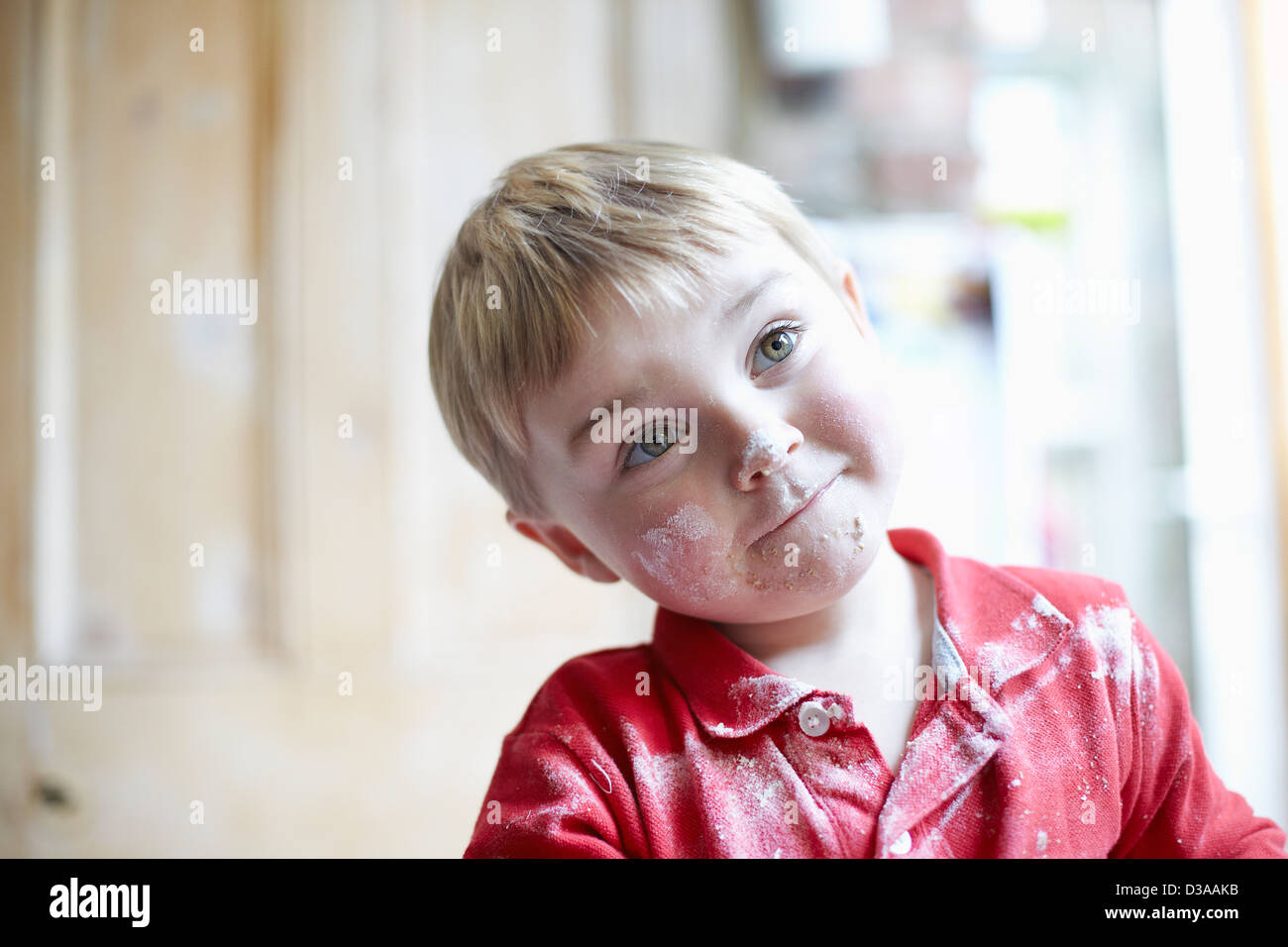 Jungen-Gesicht mit Mehl in Küche Stockfoto