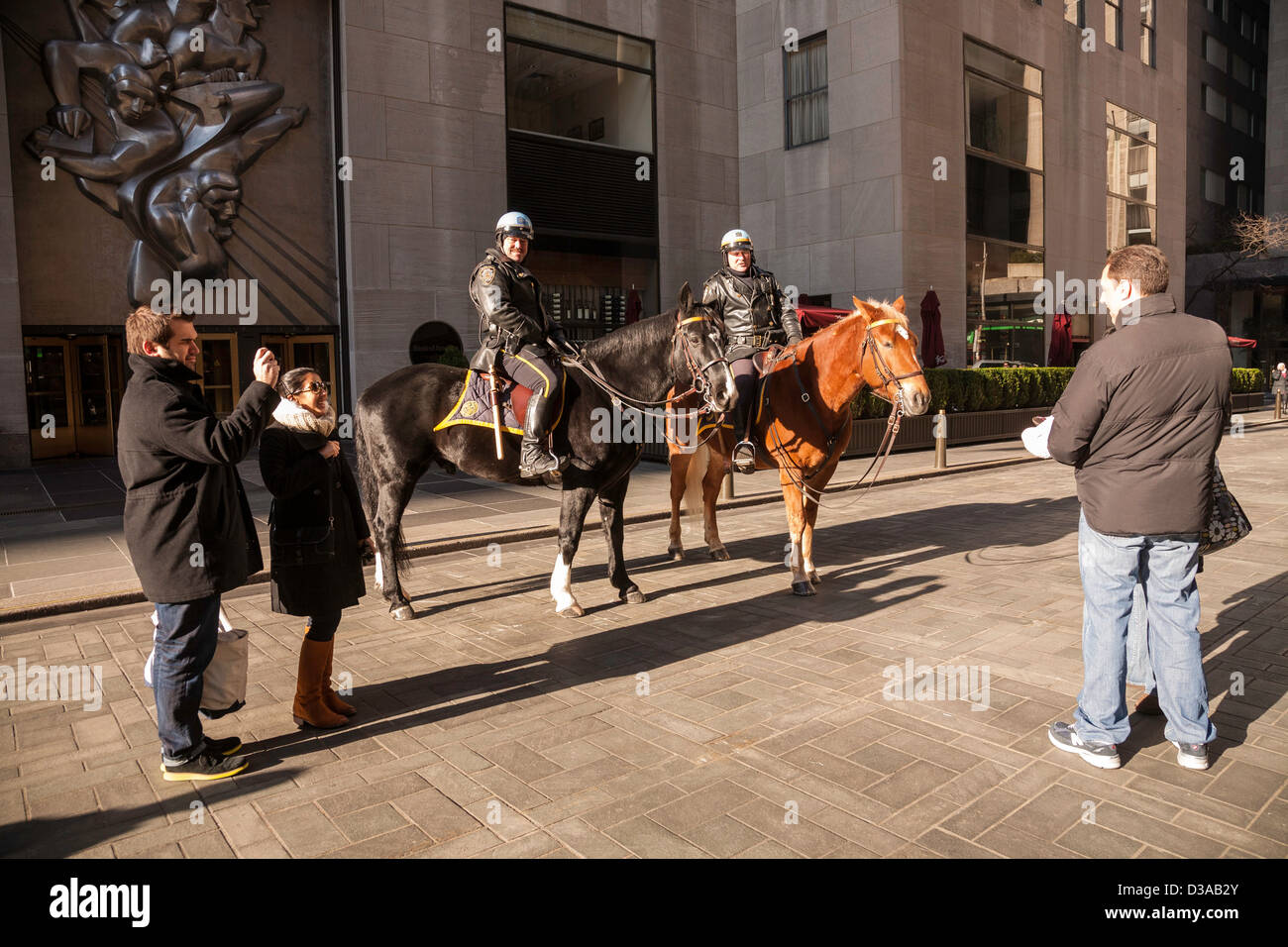 Touristen, die Aufnahme von montiert Polizisten im Rockefeller Center, NYC Stockfoto