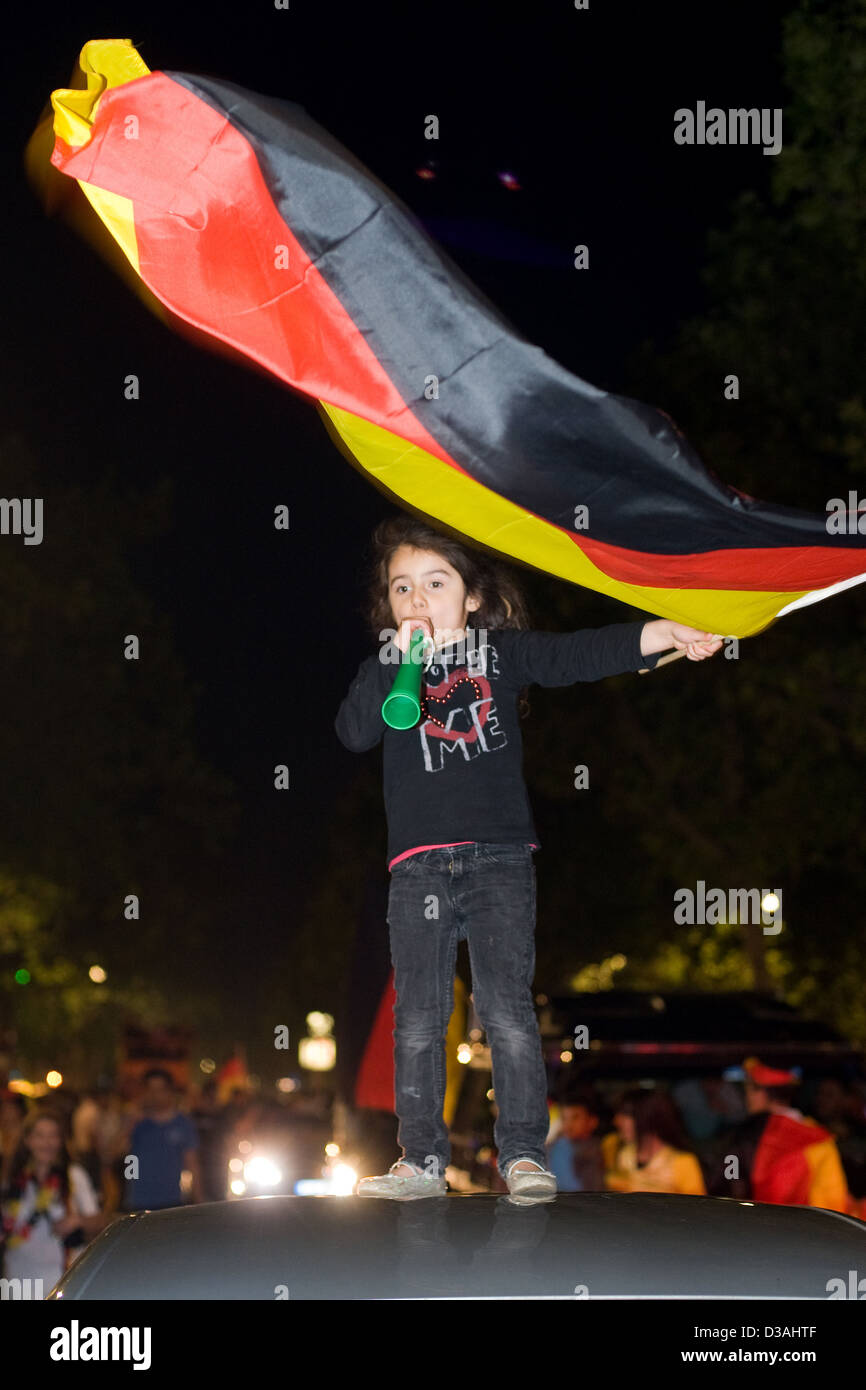 Berlin, Deutschland, schwang eine Mädchen auf einem Autodach die Deutschland-Flagge Stockfoto