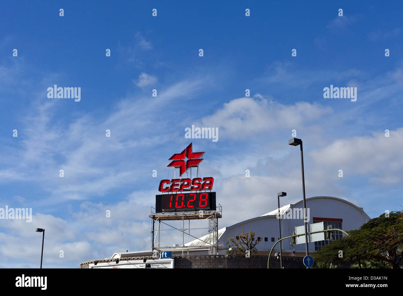 CEPSA Leuchtreklame und Digital clock in rot vor blauem Himmel mit helle Wolke in Santa Cruz De Tenerife, Kanarische Inseln, Spanien. Stockfoto