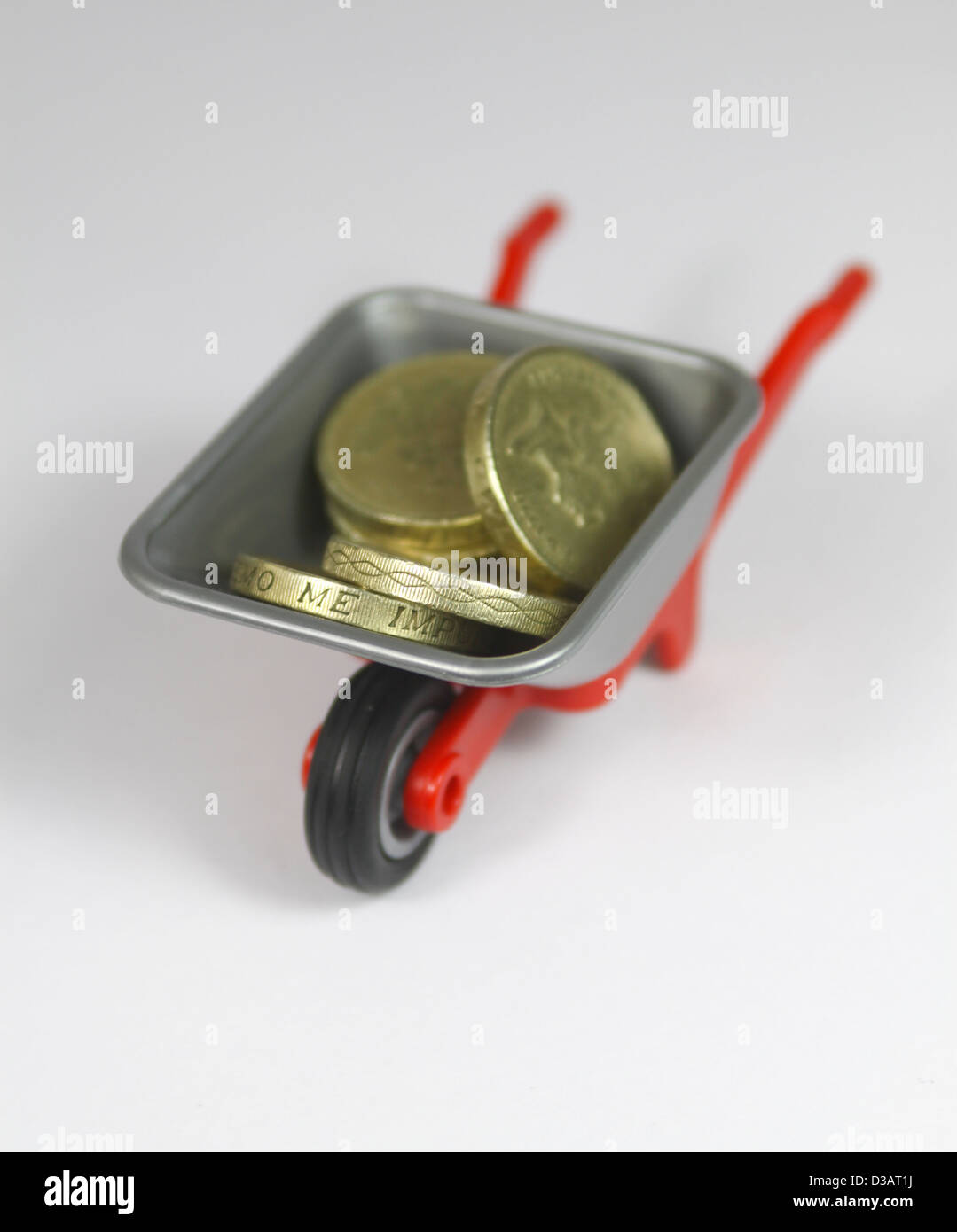 Pfund-Münzen in Kunststoff-Spielzeug Schubkarre Stockfoto