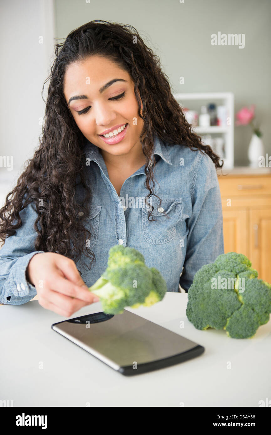 Hispanic Frau mit einem Gewicht von Brokkoli in Küche Stockfotografie -  Alamy