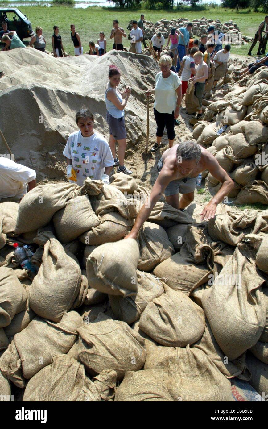 (Dpa) - in Erwartung der Flut des Flusses Elbe, freiwillige Helfern füllen Sandsäcke in Alt Lostau, in der Nähe von Magdeburg, Deutschland, 16. August 2002. Hochwasser drücken noch nordwärts durch Deutschland, eine Spur der Verwüstung entlang der Elbe zu erweitern. Stockfoto