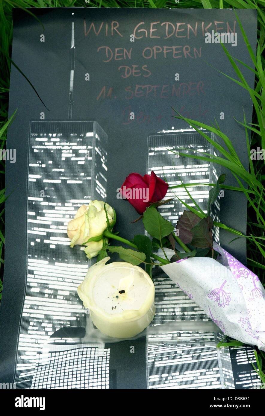 (Dpa) - eine Kerze und zwei Rosen auf einem Plakat zeigt die Zwillingstürme des World Trade Center vor den USA konsularischen allgemein in Hamburg, 11. September 2002 gestellt werden. Deutschlands zentrale Trauerfeier fand in der Kathedrale in Berlin statt. Am ersten Jahrestag der Anschläge waren die Opfer com Stockfoto