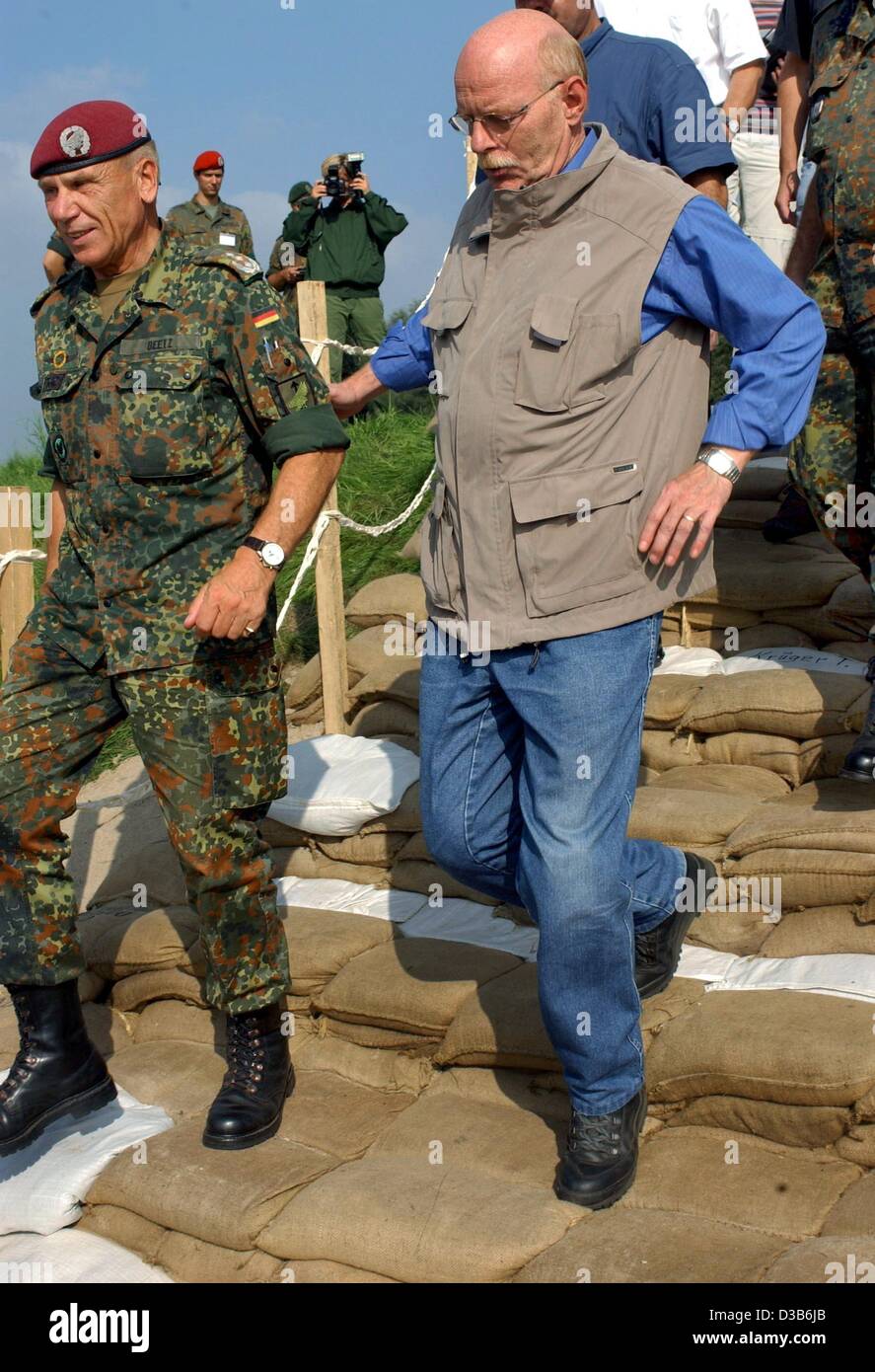 (Dpa) - die deutsche Verteidigung-Minister Peter Struck und ein Bundeswehr-Offizier-Spaziergang durch eine Treppe aus Sandsäcken auf dem Elbe-Deich in der Nähe von Lauenburg, Norddeutschland, 25. August 2002. Die Minister kamen, um einen Eindruck von der Situation des Gebiets durch die Flut bedroht und die Soldaten für Thei danken Stockfoto