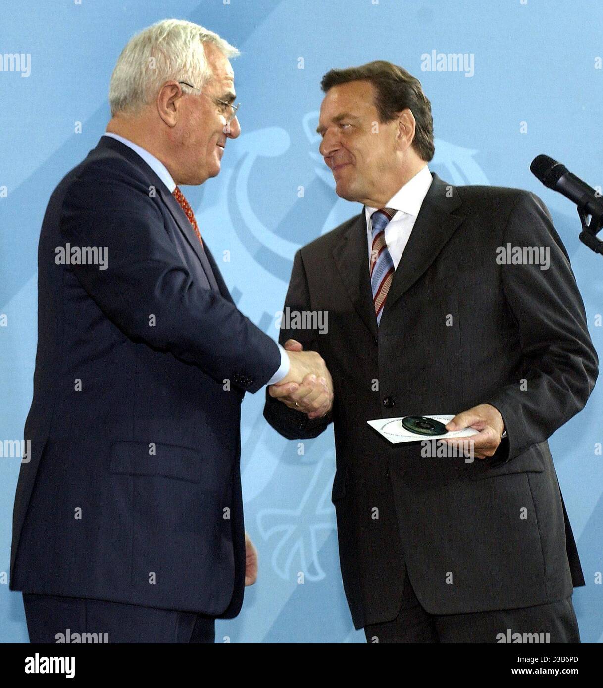 (Dpa) - German Chancellor Gerhard Schroeder (R) schüttelt Hände mit Peter Hartz, Leiter der so genannten "Hartz-Kommission", nach Erhalt der CD-ROM mit dem Bericht über die schneiden Arbeitslosigkeit in Berlin, 16. August 2002. Die Regierungskommission arbeitete an Reformen im deutschen Arbeitsmarkt t Stockfoto