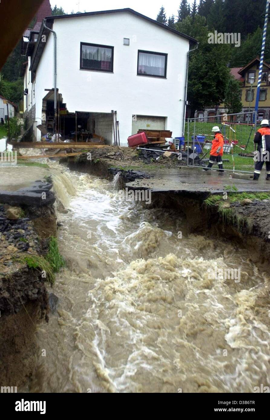 (Dpa) - eine Flut von Wasser wäscht eine Straße und Teile eines Hauses im Dorf Vogloed in der Nähe von Passau, Deutschland, 12. August 2002. Nach sintflutartigen Regenfällen wurde der Ausnahmezustand in sechs bayerischen Regionen erklärt. Weiterhin Regen hat in mehreren Bundesländern Überschwemmungen verursacht. Stockfoto